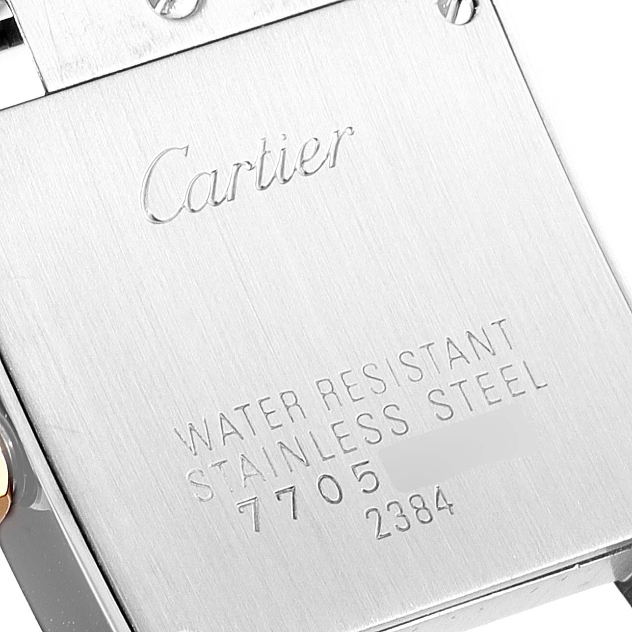 The image shows the back case of a Cartier Tank Francaise W51007Q4 Women
s Steel and Gold (two tone) Silver Dial W51007Q4 Women
s Steel and Gold (two tone) Silver Dial watch, featuring engraved details like the brand name and material information.