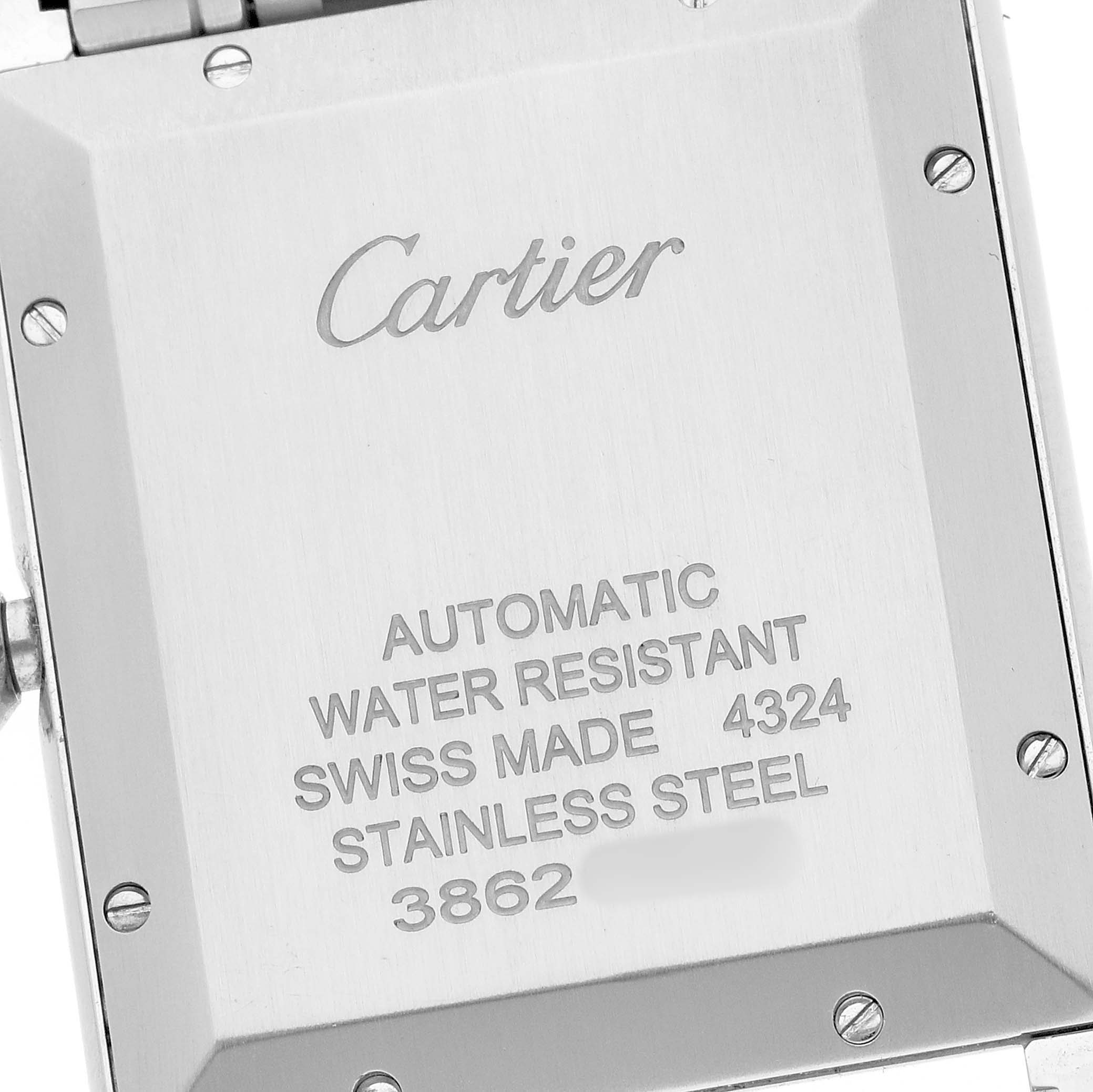 The image shows the back of a Cartier Tank Must WSTA0053 Men's Stainless Steel Silver Dial watch, displaying engraving and screws.