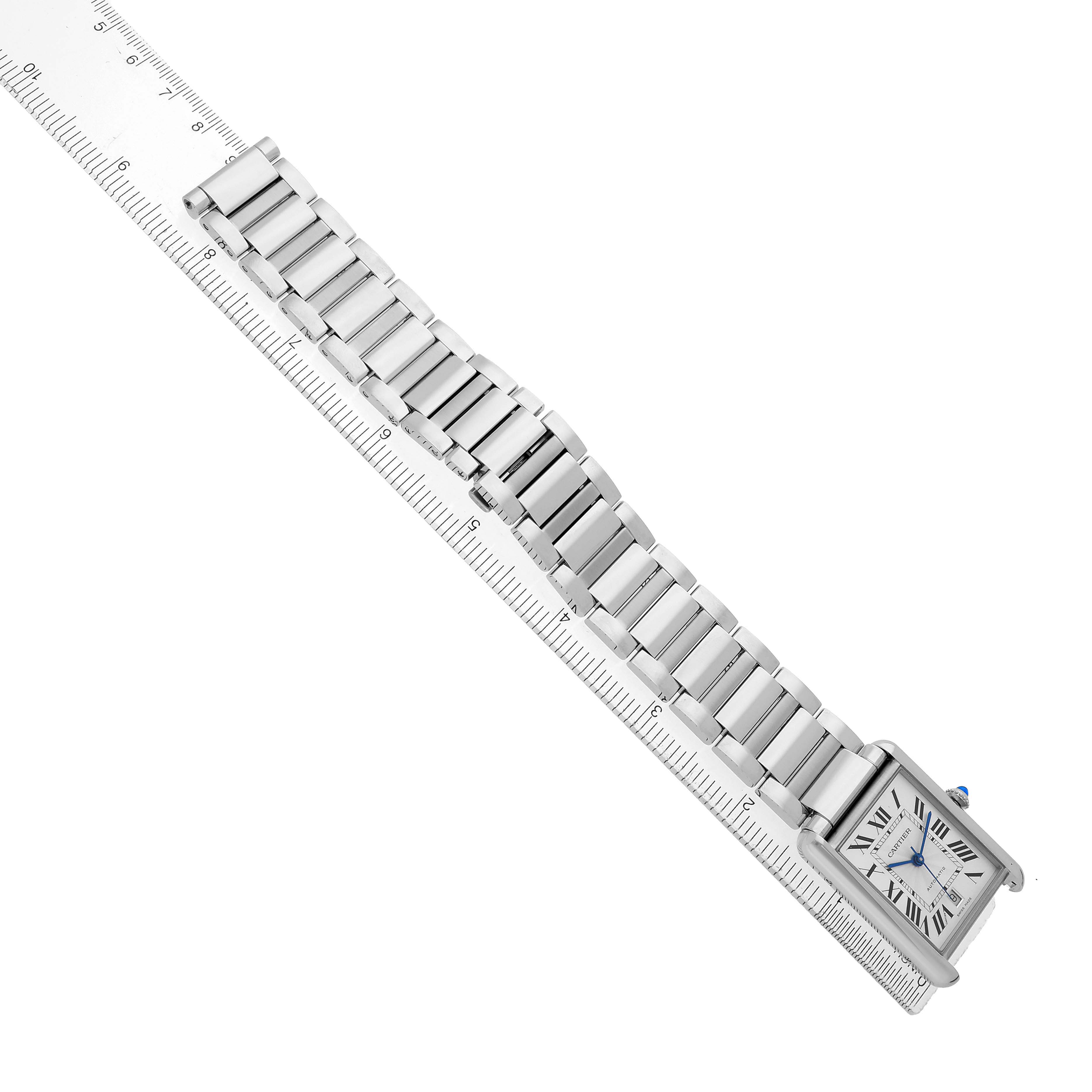 The Cartier Tank Must WSTA0053 Men's Stainless Steel Silver Dial watch is shown from a top view, displaying the bracelet and rectangular face next to a ruler for scale.