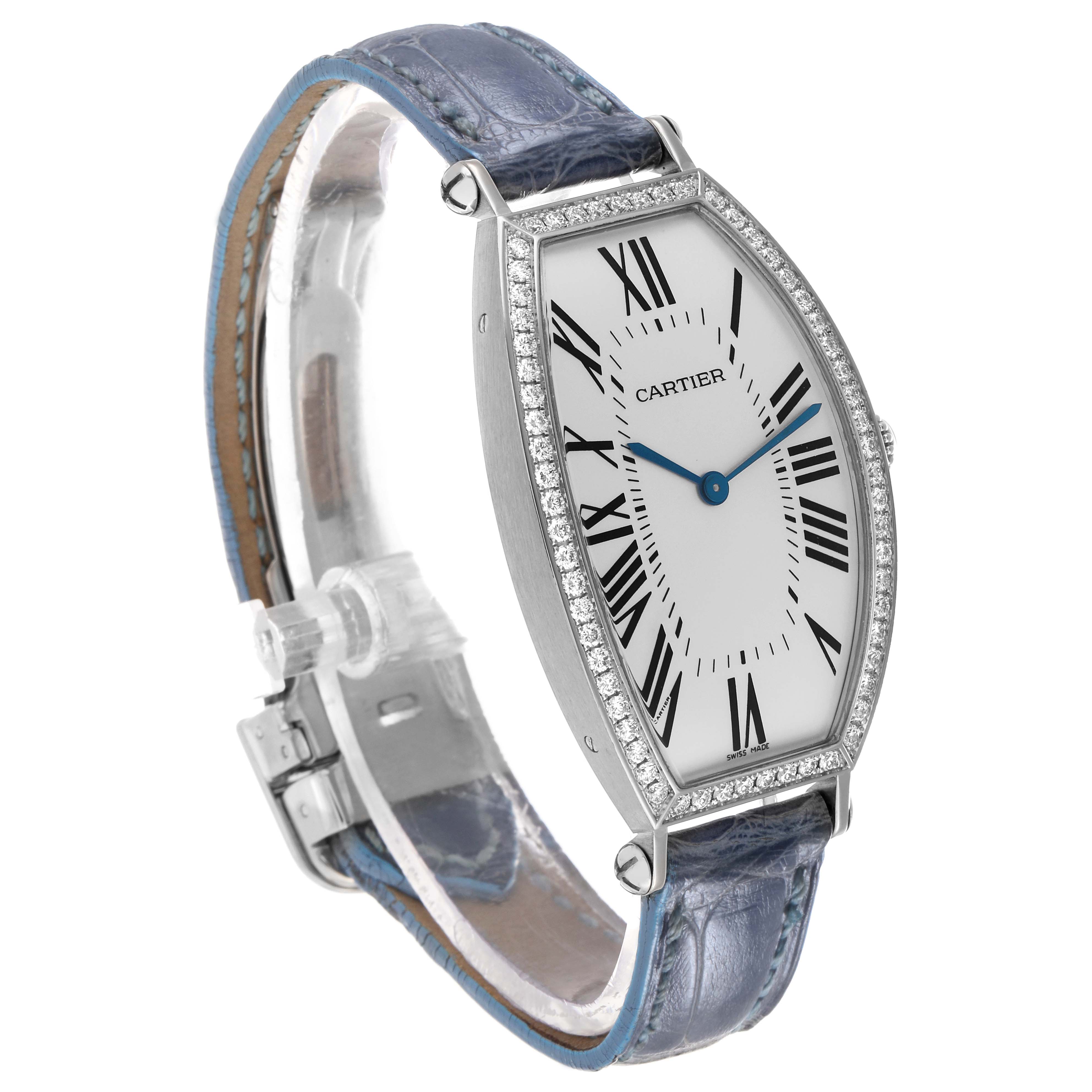 The Cartier Tonneau WE400251 Women's White Gold Silver Dial model is shown at a three-quarter angle, displaying its diamond-encrusted case, blue hands, and leather strap.