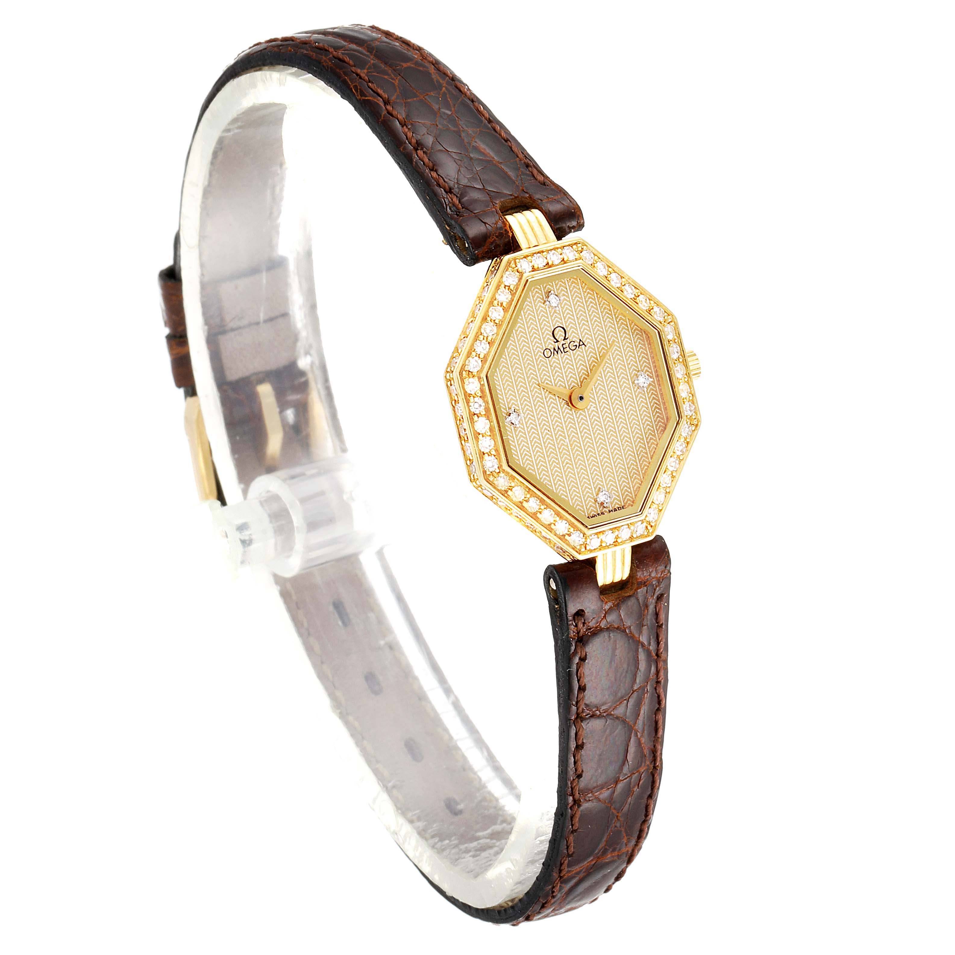 The image shows a side angle view of the Omega 1450 Women's Yellow Gold Champagne Dial 1450 Women's Yellow Gold Champagne Dial DeVille Mini Yellow Gold Diamond Cocktail Ladies Watch 1450, highlighting its gold hexagonal face and brown leather strap.