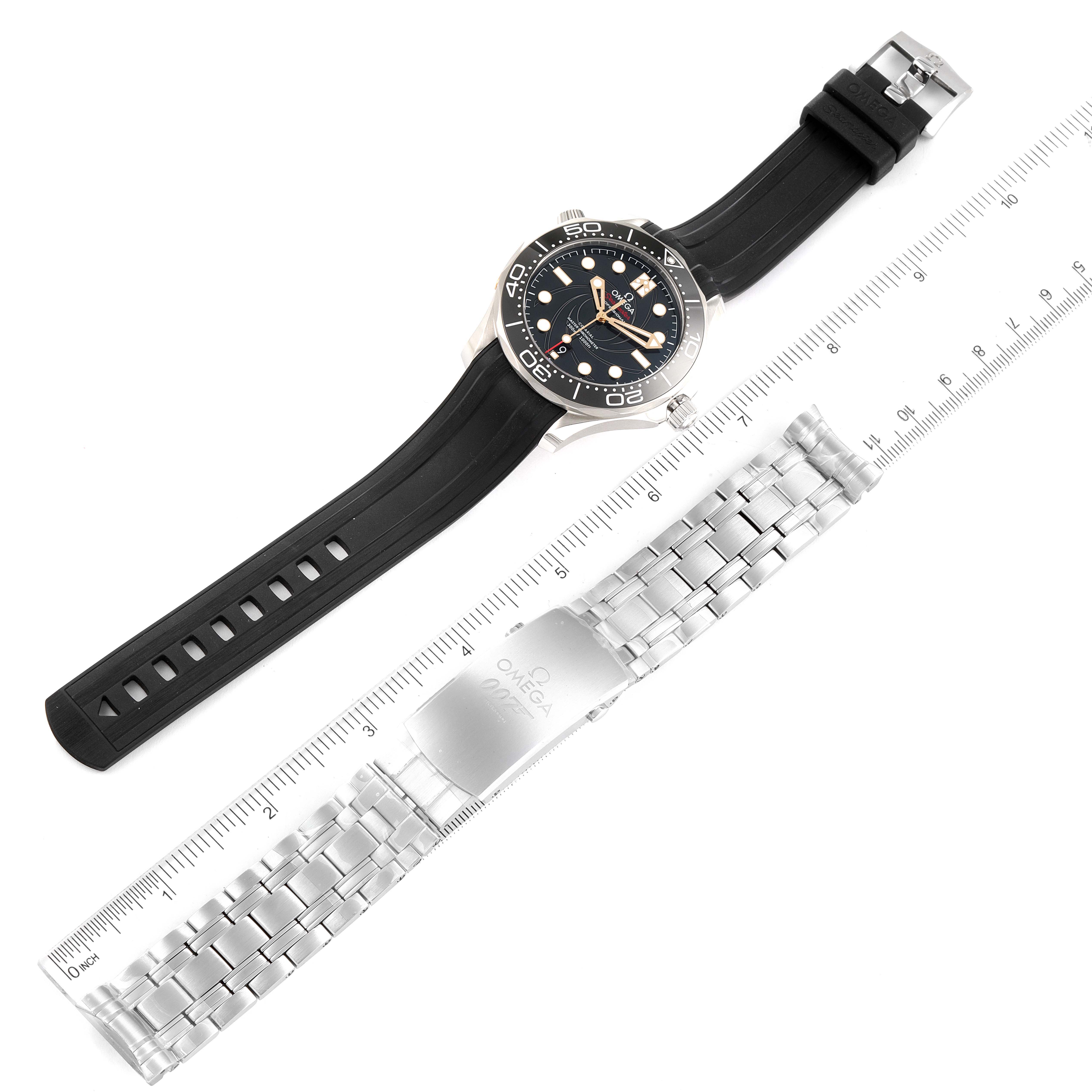 The image shows an Omega Seamaster 210.22.42.20.01.004 Men's Stainless Steel Black Dial 210.22.42.20.01.004 Men's Stainless Steel Black Dial watch with a black strap, and a separate silver metal bracelet next to a ruler.