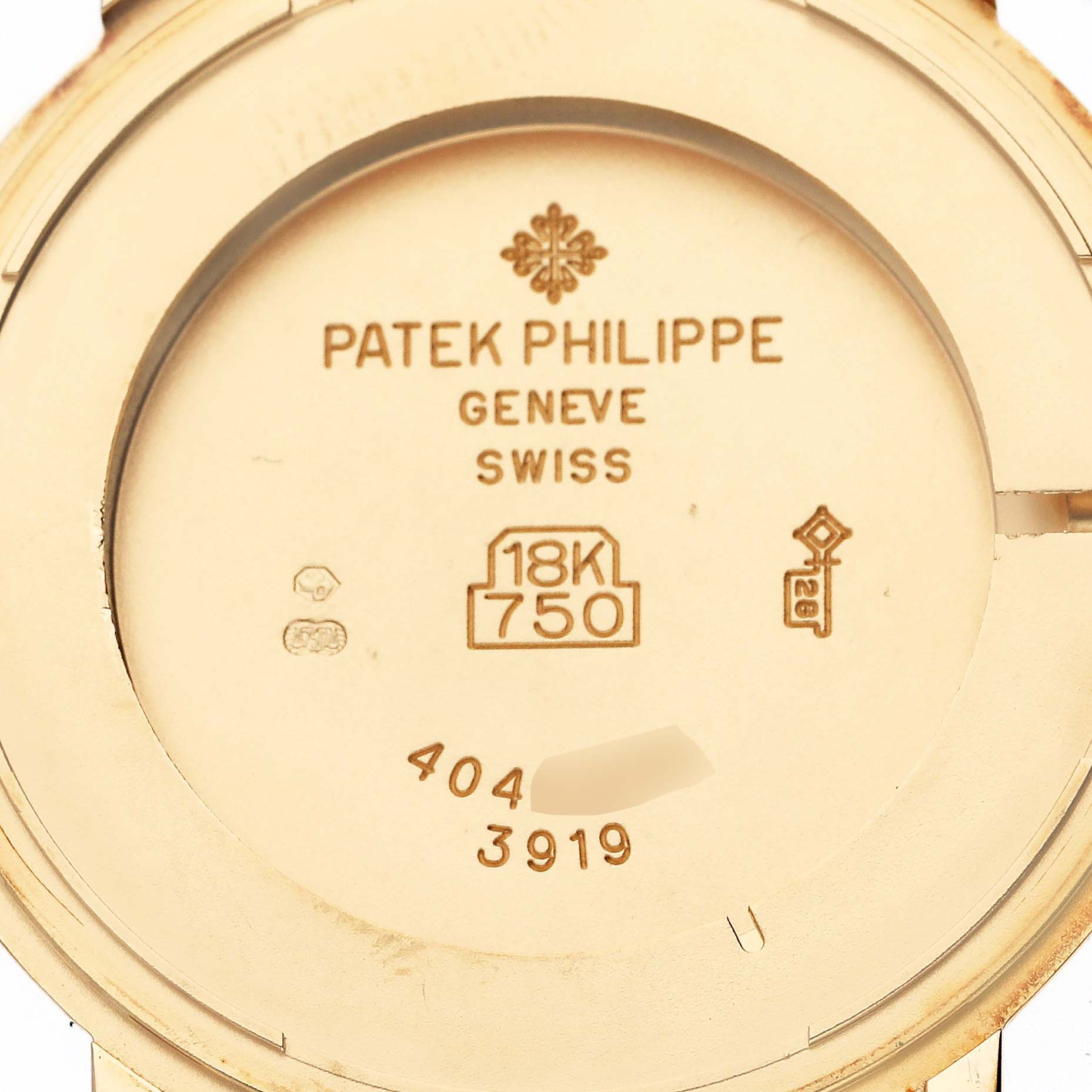 The image shows the engraved back case of a Patek Philippe Calatrava 3919J Men's Yellow Gold White Dial 3919J Men's Yellow Gold White Dial, featuring hallmark details and gold markings.