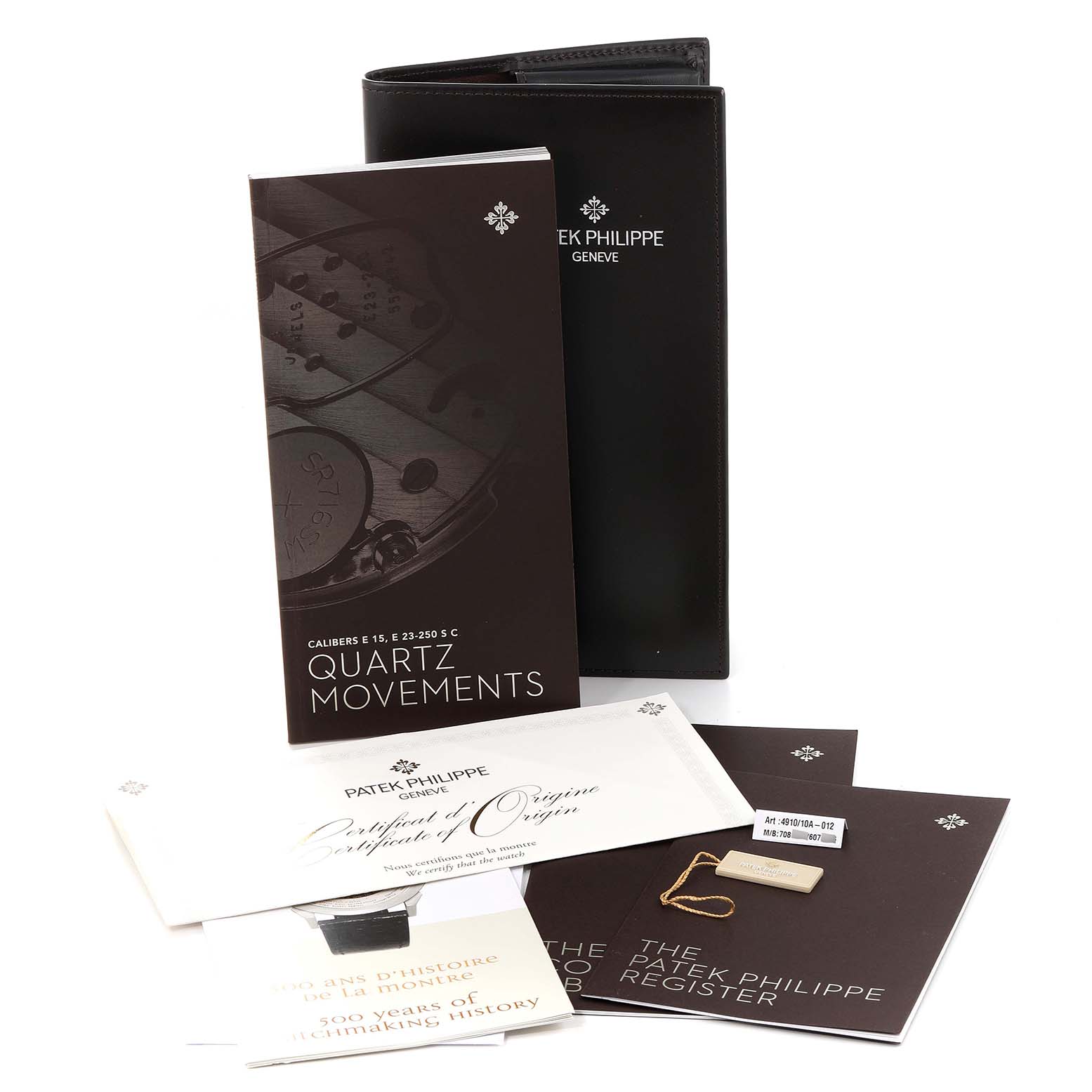 This image shows the documentation and accessories for a Patek Philippe Twenty-4 4910/10A-012 Women's Stainless Steel Blue Dial 4910/10A-012 Women's Stainless Steel Blue Dial model, including manuals, certificates, and a tag.