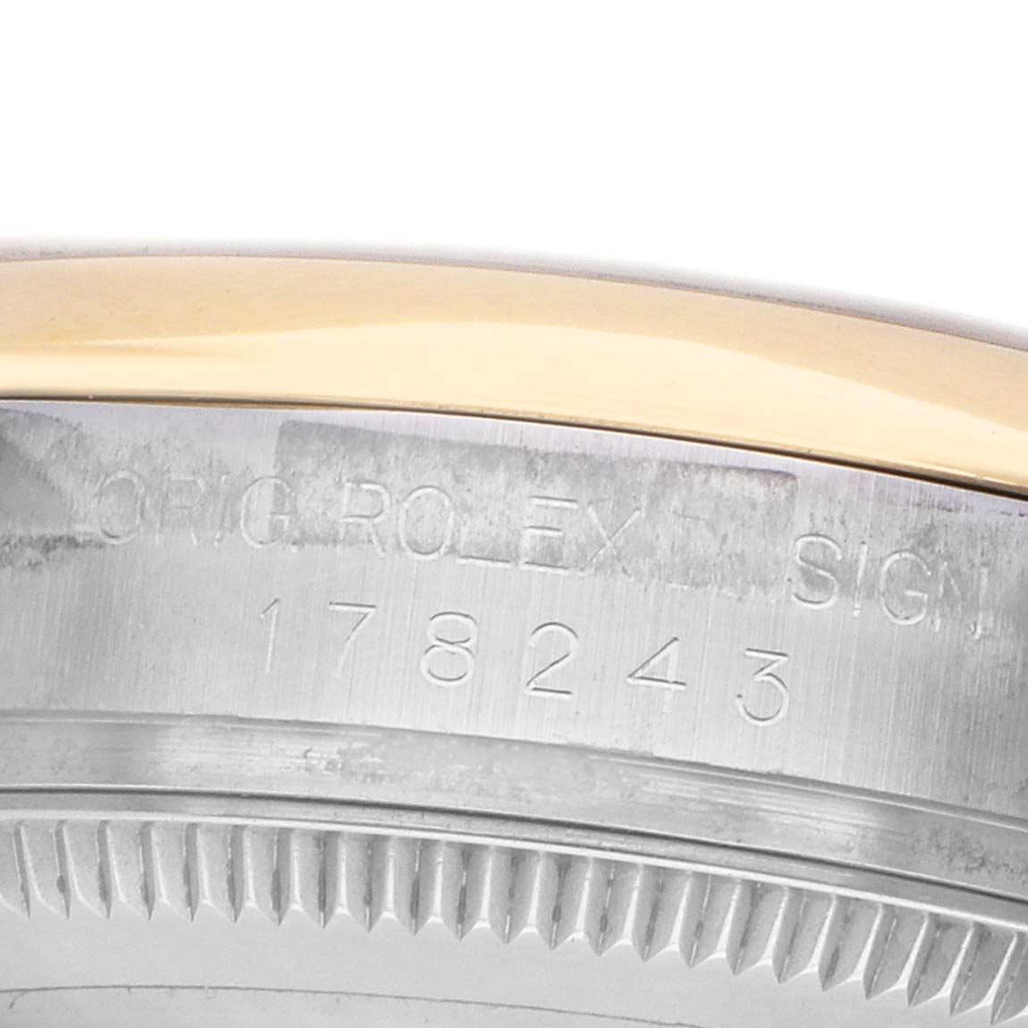 The image shows a close-up of a Rolex Mid-Size 178243 Women's Steel and Gold (two tone) Silver Dial watch case with engraved text and numbers.