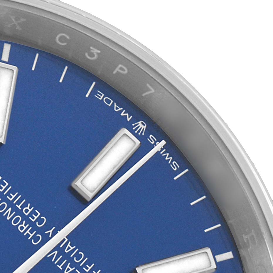 The image shows a close-up of the Rolex Datejust 126200 Men's Stainless Steel Blue Dial's blue dial, highlighting the hour markers and a partial view of the bezel.