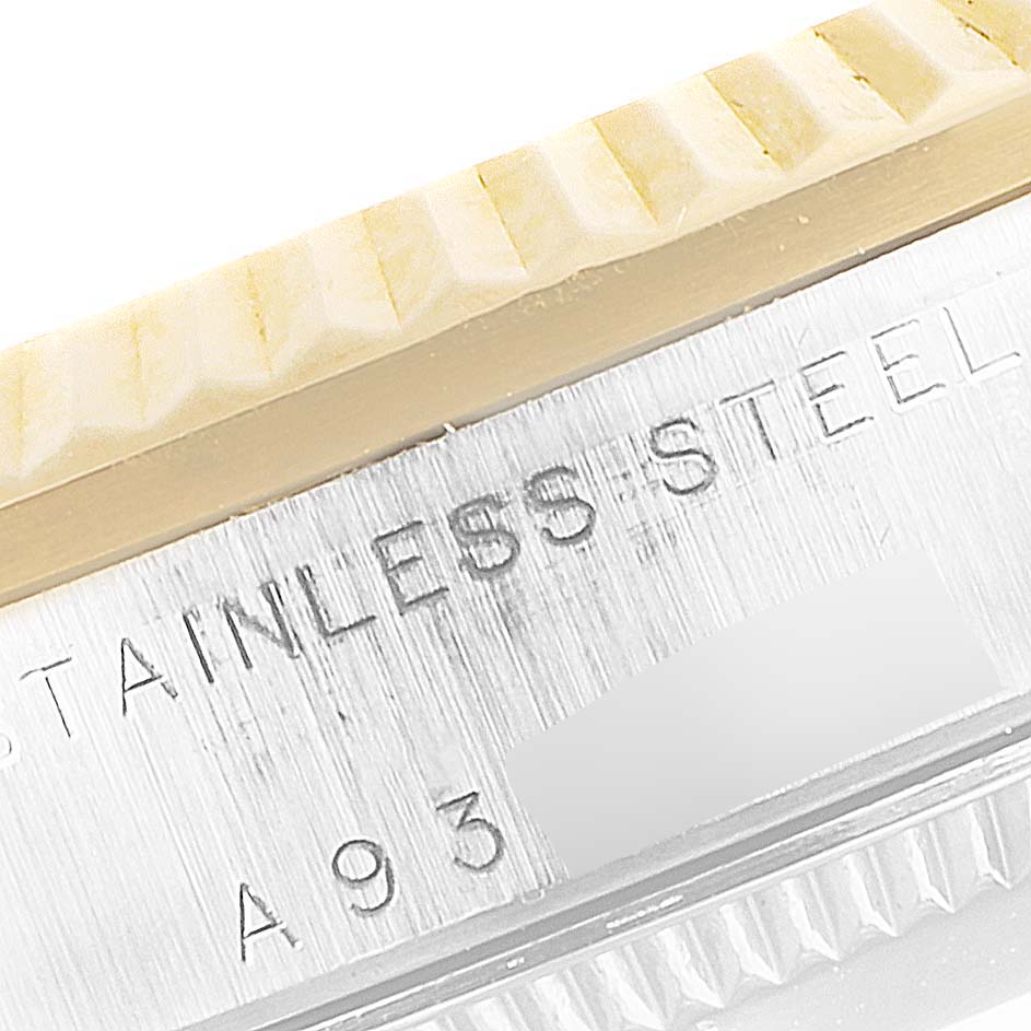 The image shows a close-up of the mid-size Rolex watch, specifically the stainless steel bezel and part of the engraving.