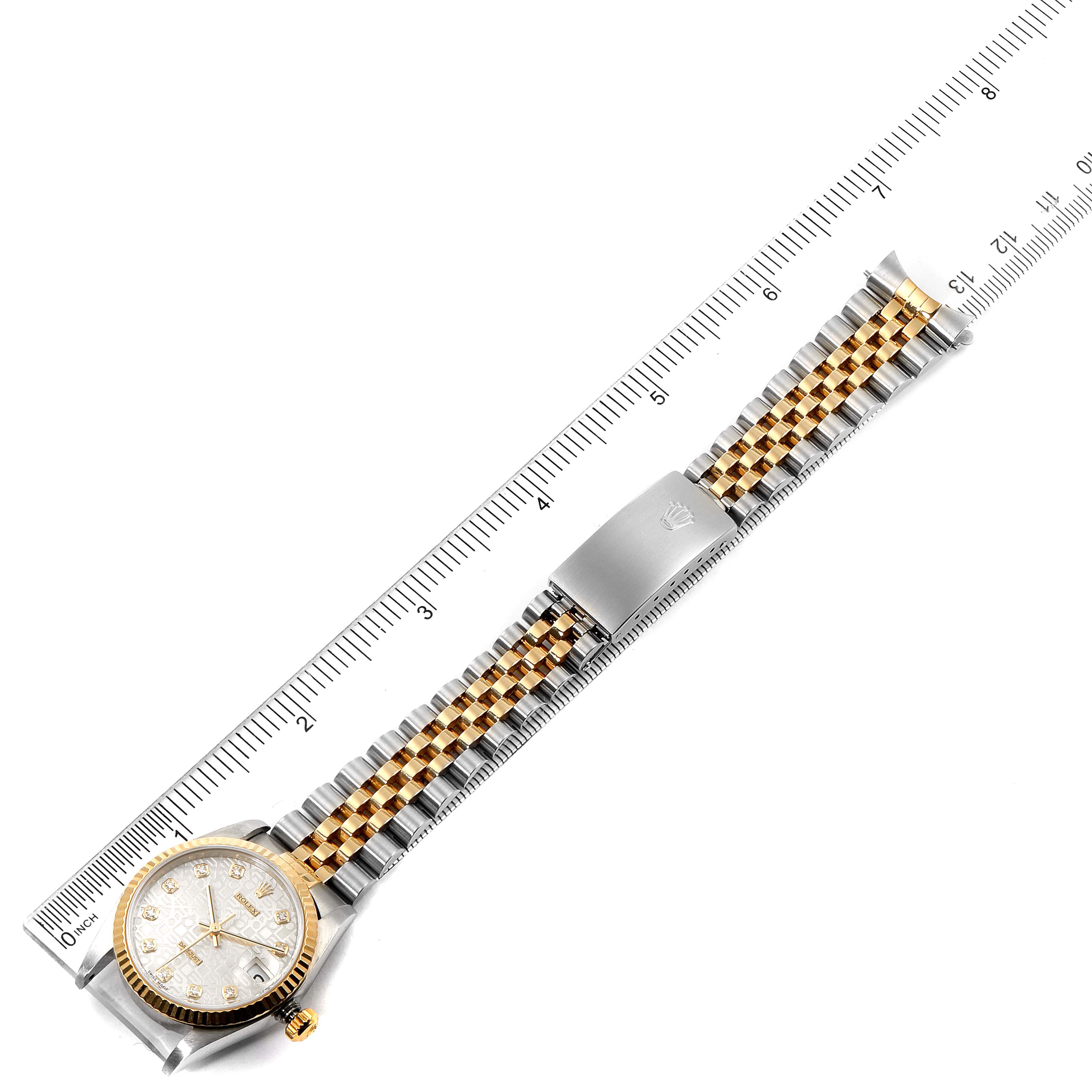 The Rolex Mid-Size 78273 Women
s Steel and Gold (two tone) Silver Dial 78273 Women
s Steel and Gold (two tone) Silver Dial watch is shown from a top-down angle, displaying the face, bezel, and full bracelet with a ruler for measurement.