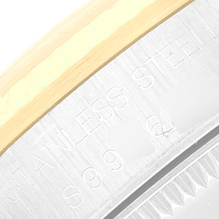 This image shows a close-up of the outer edge, bezel, and the "STAINLESS STEEL" engraving of a Mid-Size Rolex watch.