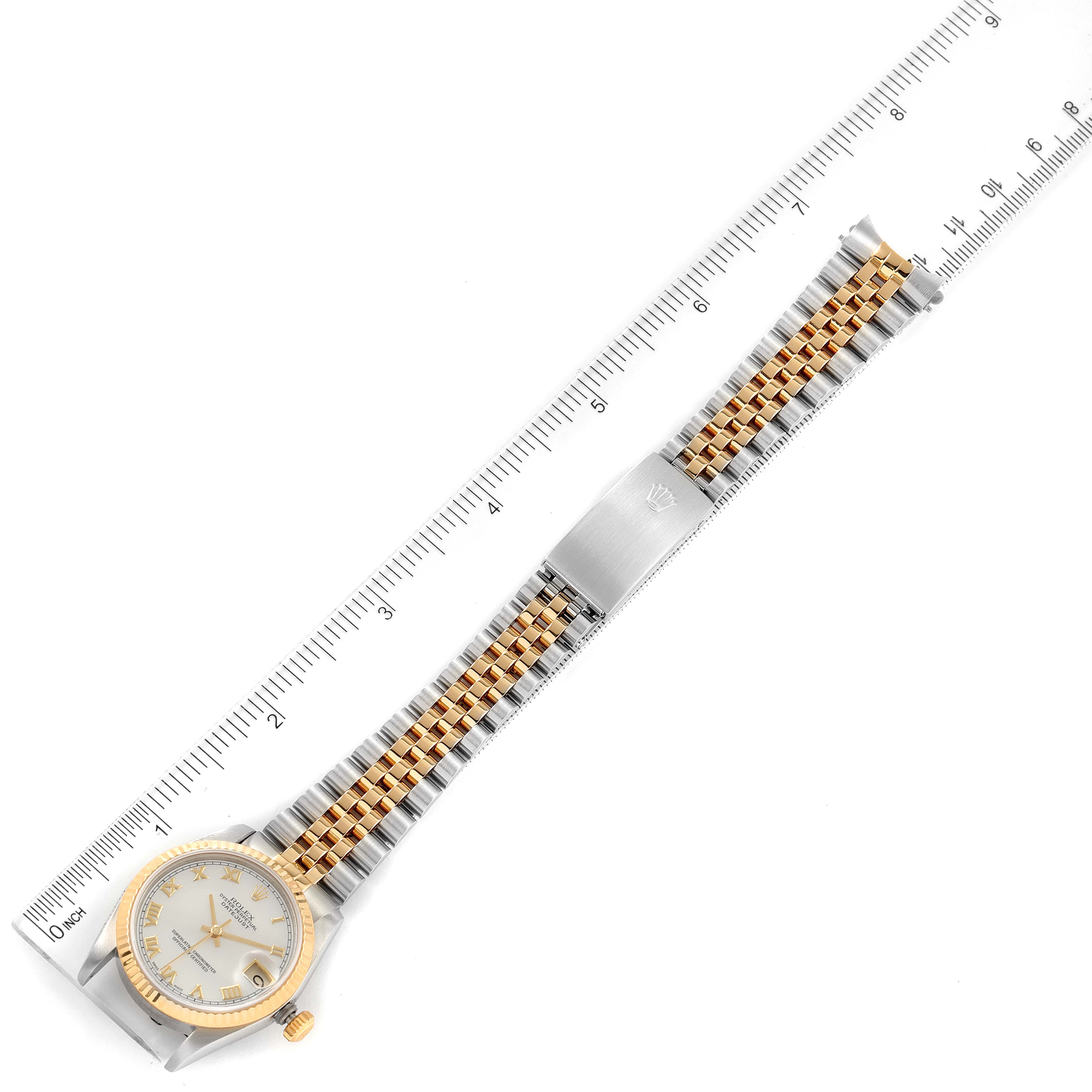 The image shows a top view of a Mid-Size Rolex watch, highlighting the face, bezel, and jubilee bracelet with a ruler for scale.