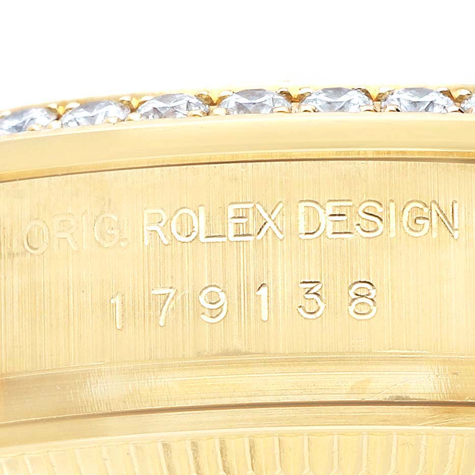 The image shows a close-up of the Rolex President 179138 Women's Yellow Gold Champagne Dial 179138 Women's Yellow Gold Champagne Dial model bezel with diamond detailing and engraved model number.