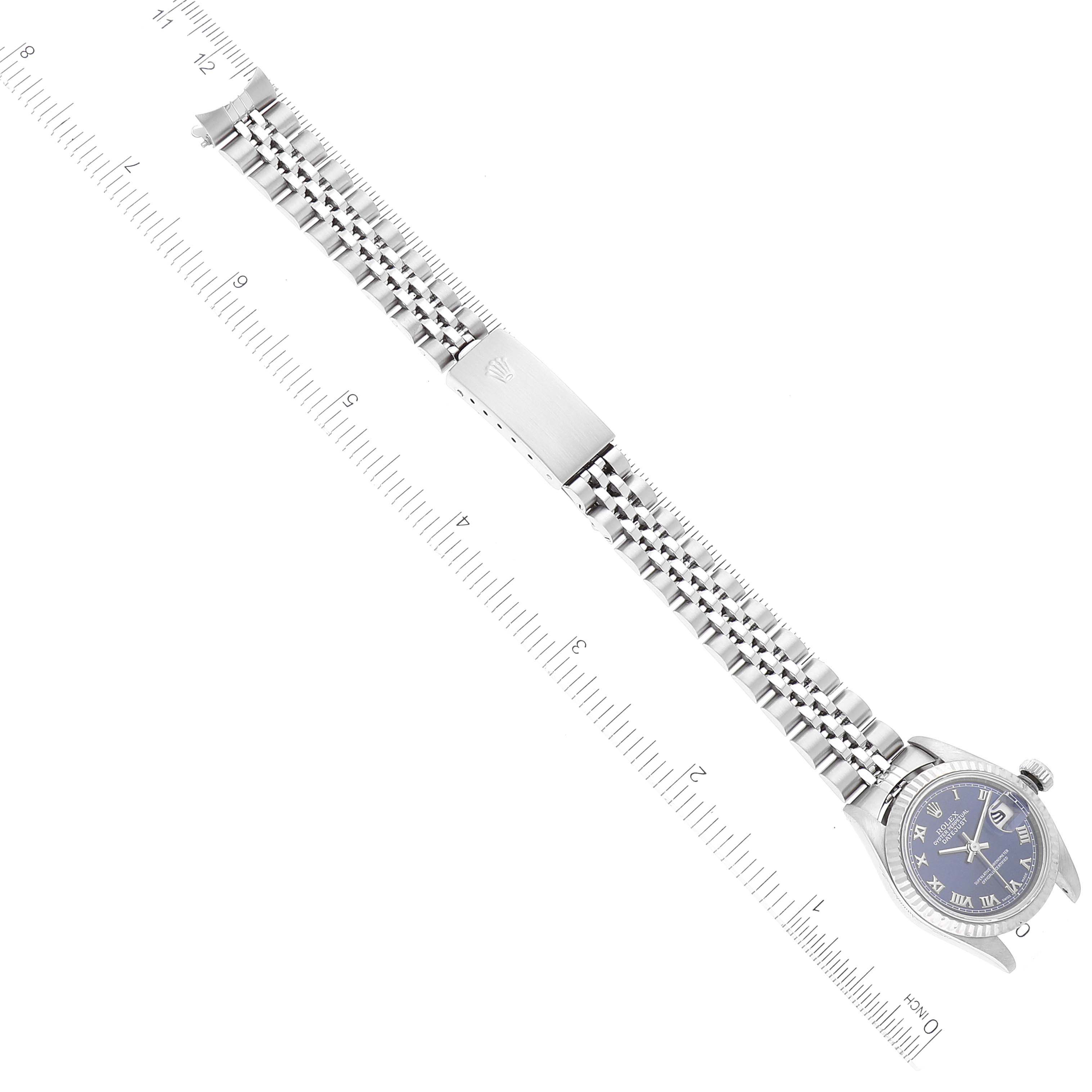 The image shows the entire Rolex Datejust 79174 Women's Stainless Steel Blue Dial 79174 Women's Stainless Steel Blue Dial watch laid flat, with the face, bezel, bracelet, and clasp, alongside a ruler for size reference.