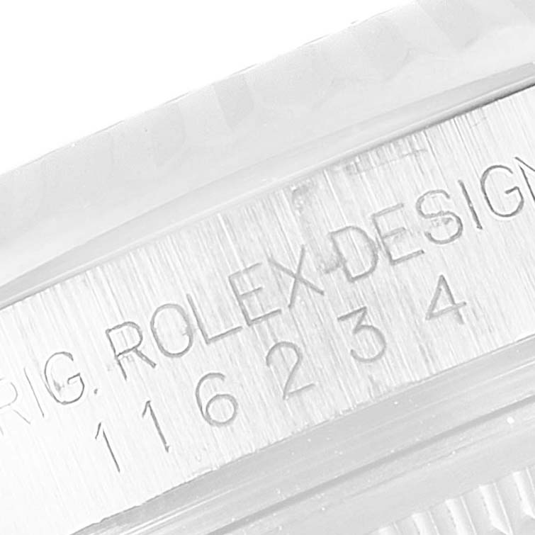 The image shows an engraved part of the Rolex Datejust 116234 Men's Stainless Steel Silver Dial 116234 Men's Stainless Steel Silver Dial watch case from a close-up angle.