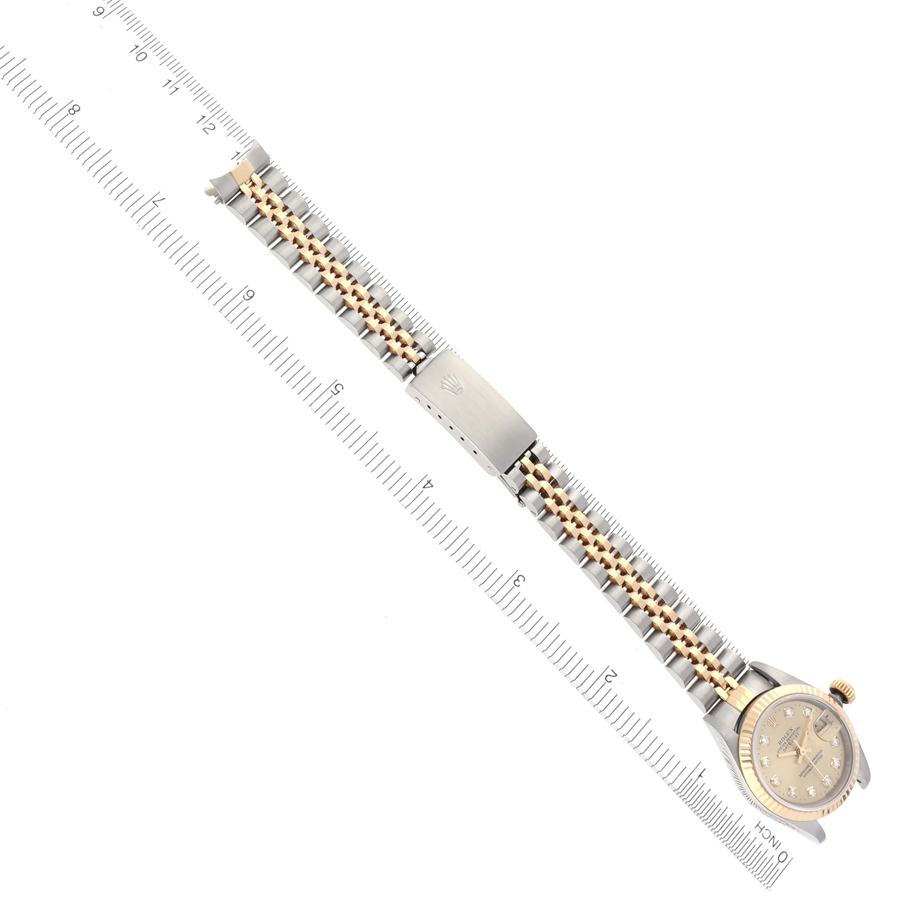 The Rolex Datejust 69173 Women's Steel and Gold (two tone) Champagne Dial 69173 Women's Steel and Gold (two tone) Champagne Dial watch is shown fully extended with its bracelet and clasp visible, alongside a ruler for scale.