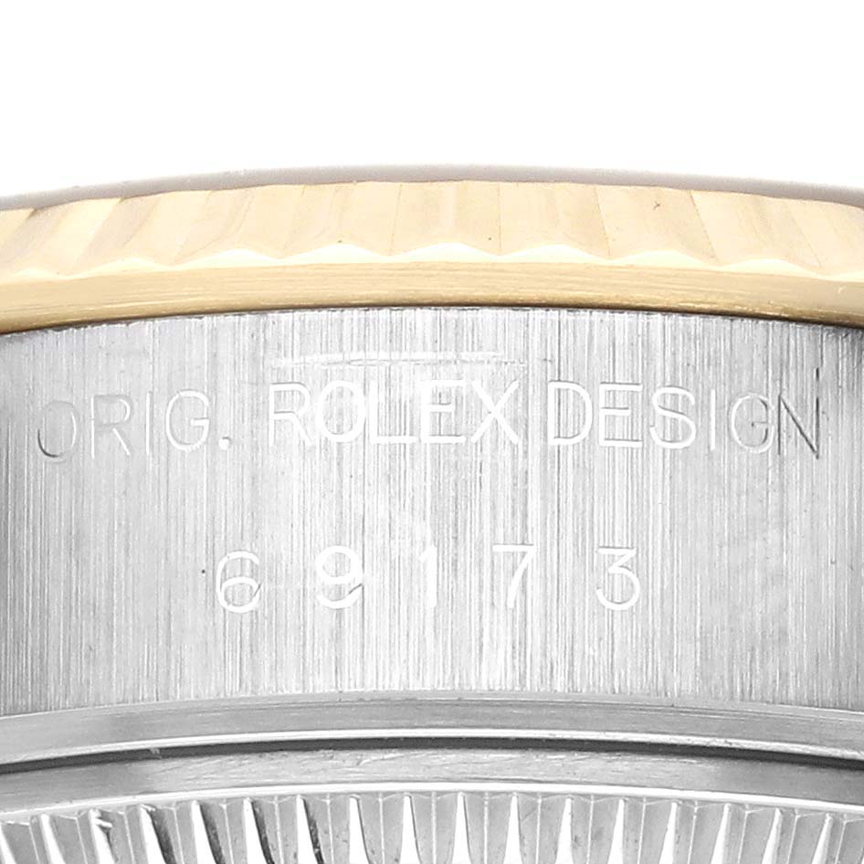 The image shows the side engraving and part of the bezel of a Rolex Datejust 69173 Women's Steel and Gold (two tone) Champagne Dial 69173 Women's Steel and Gold (two tone) Champagne Dial watch.