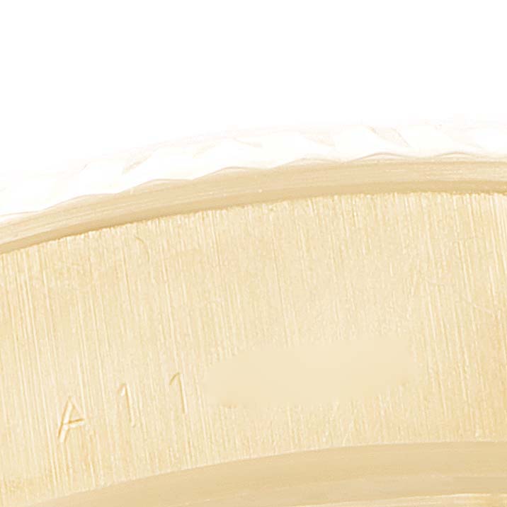 This close-up image of the President model by Rolex shows a portion of the watch
s bezel and case with some engraved text.