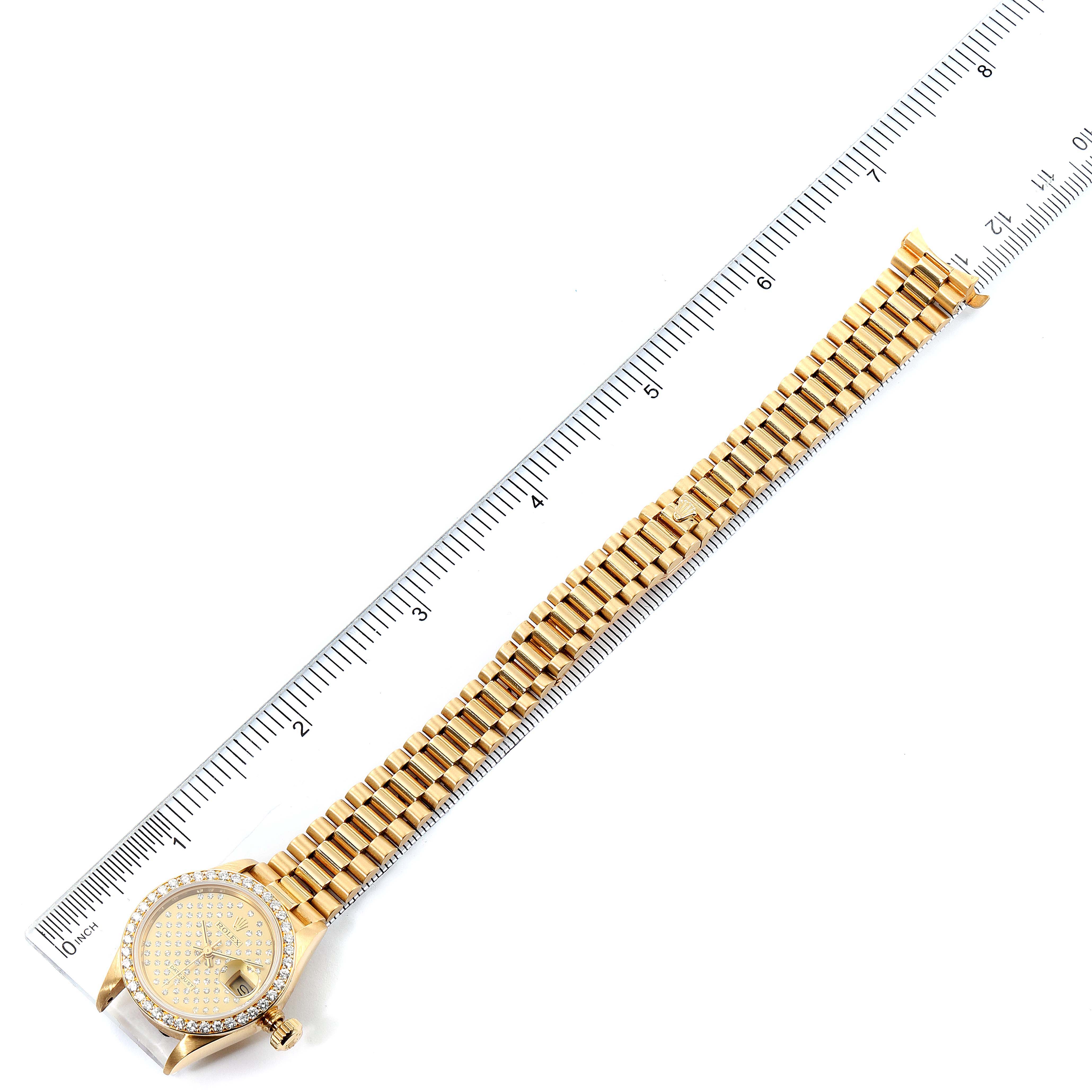The image shows a full-length view of the Rolex President 69138 Women
s Yellow Gold Champagne Dial 69138 Women
s Yellow Gold Champagne Dial model watch, including the dial, bezel, and entire bracelet, placed next to a ruler.
