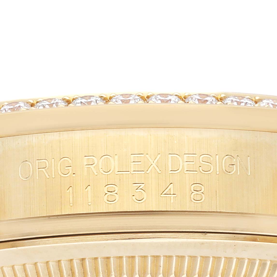 The image shows the side of a Rolex President 118348 Men's Yellow Gold Purple Dial 118348 Men's Yellow Gold Purple Dial model, displaying the engraved design number and part of the diamond-set bezel.