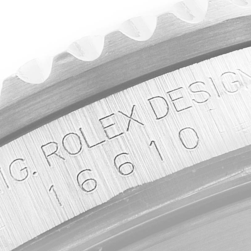 This image shows a close-up of the side engraving on a Rolex Submariner 16610 Men's Stainless Steel Black Dial 16610 Men's Stainless Steel Black Dial model, focusing on its bezel and serial number.