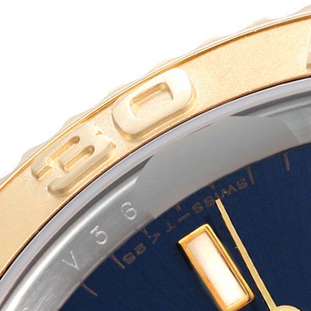 The close-up image shows part of the bezel and the dial of a Rolex Yacht-Master 16623 Men's Steel and Gold (two tone) Blue Dial 16623 Men's Steel and Gold (two tone) Blue Dial watch at an angle.