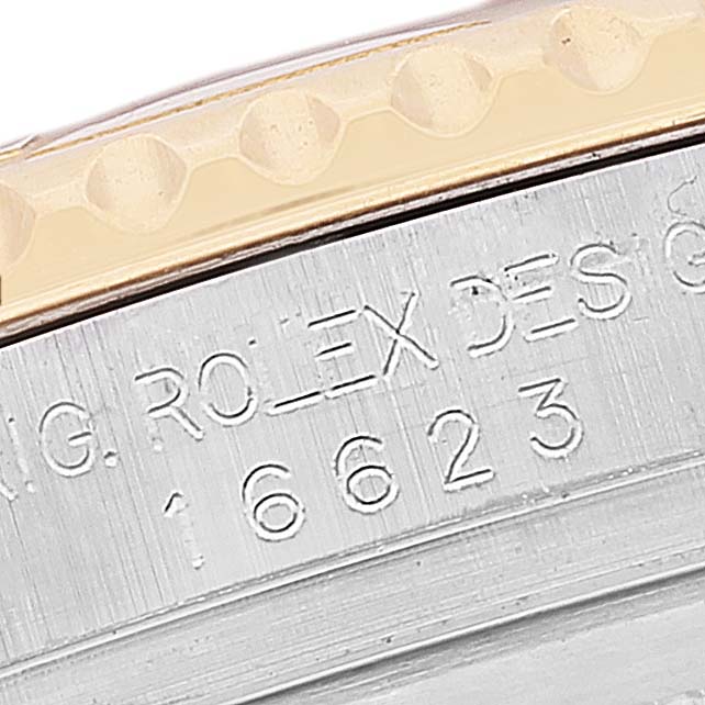 The image shows a close-up of the Rolex Yacht-Master 16623 Men's Steel and Gold (two tone) Blue Dial 16623 Men's Steel and Gold (two tone) Blue Dial's model and serial number engravings on its case.
