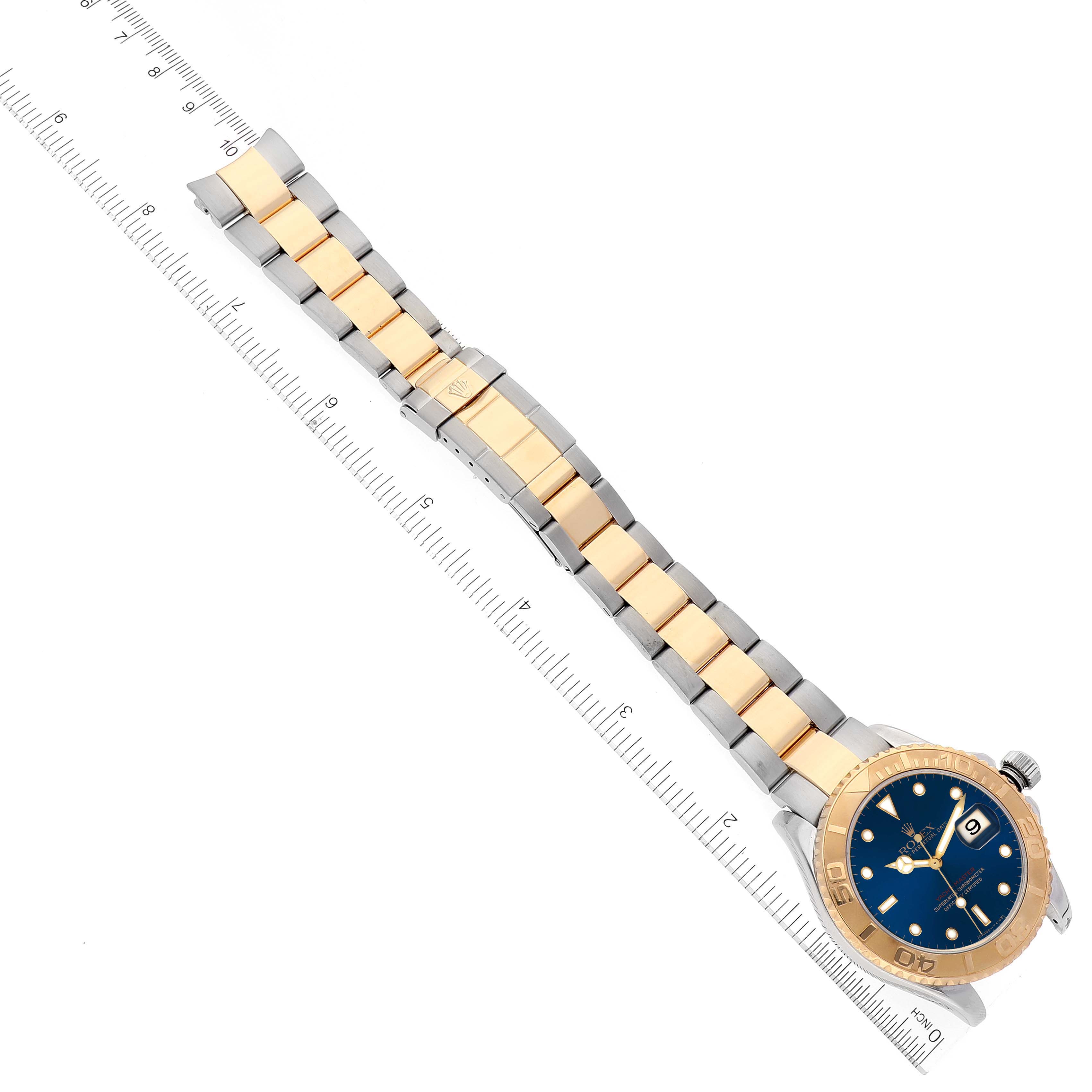 The image shows a Rolex Yacht-Master 16623 Men's Steel and Gold (two tone) Blue Dial 16623 Men's Steel and Gold (two tone) Blue Dial watch laid flat beside a ruler, highlighting the band and bezel.