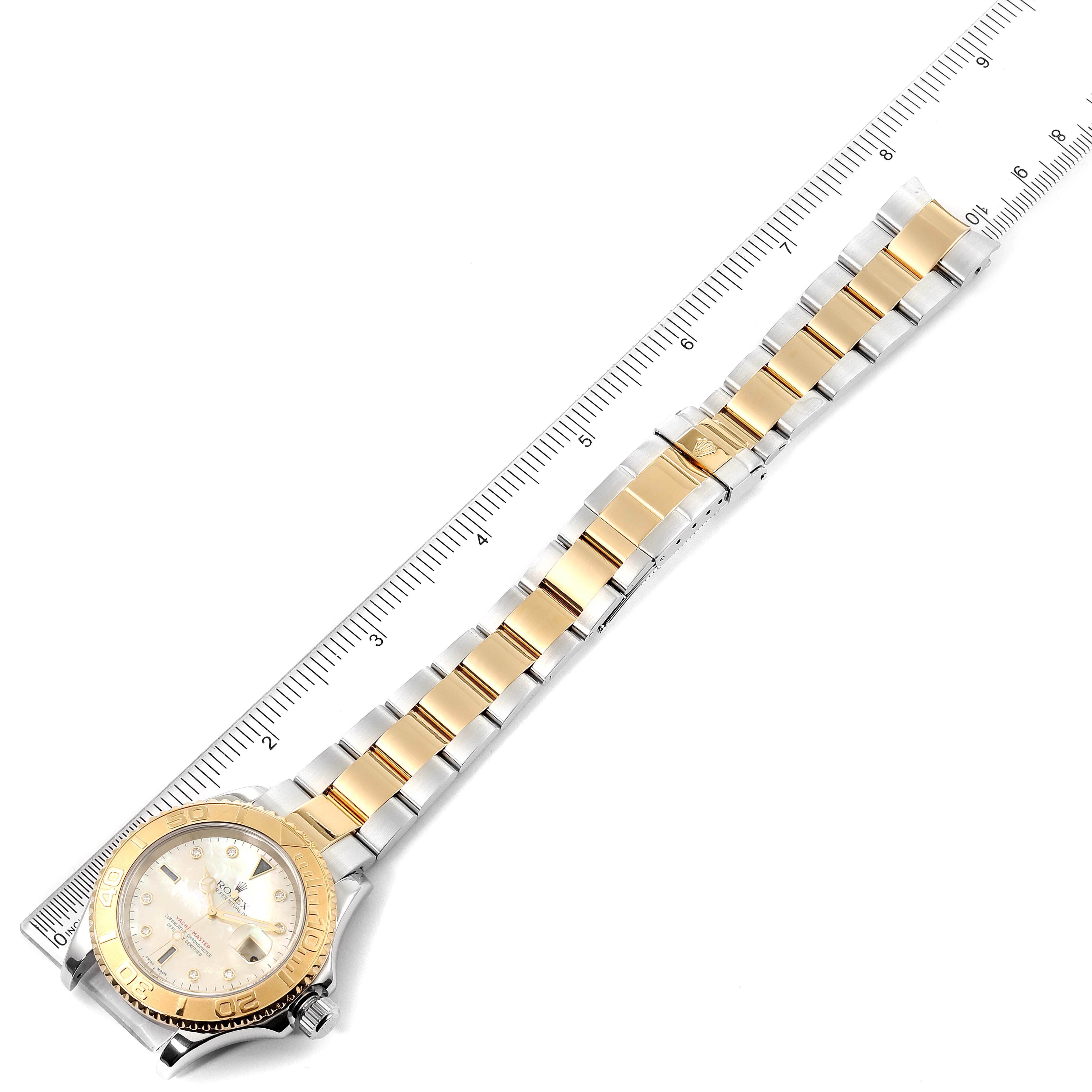 The image shows a Rolex Yacht-Master 16623 Men's Steel and Gold (two tone) Mother of Pearl Dial 16623 Men's Steel and Gold (two tone) Mother of Pearl Dial watch laid flat from an angled top-down view, with a ruler alongside it.