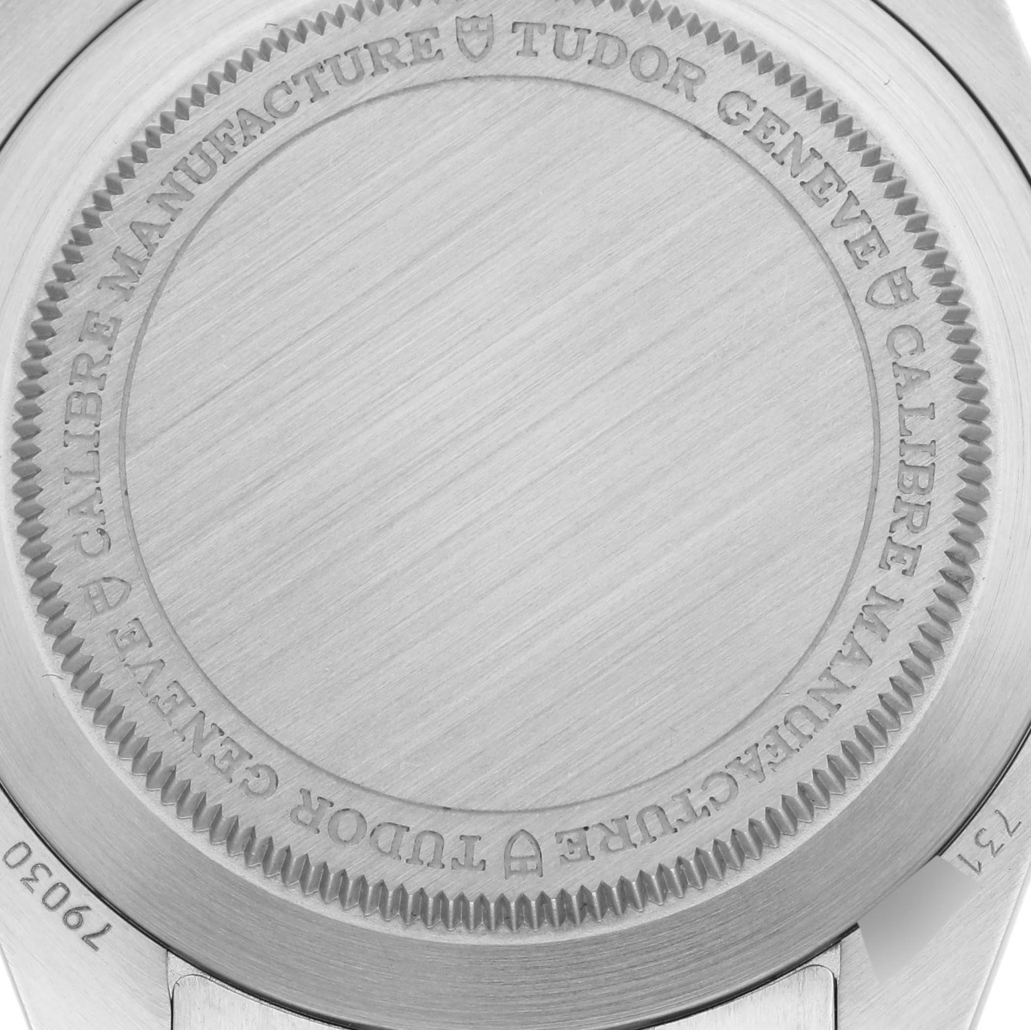 The image shows a close-up of the case back of a Tudor Heritage Black Bay 79030B Men
s Stainless Steel Blue Dial 79030B Men
s Stainless Steel Blue Dial watch, featuring engravings and brushed metal.