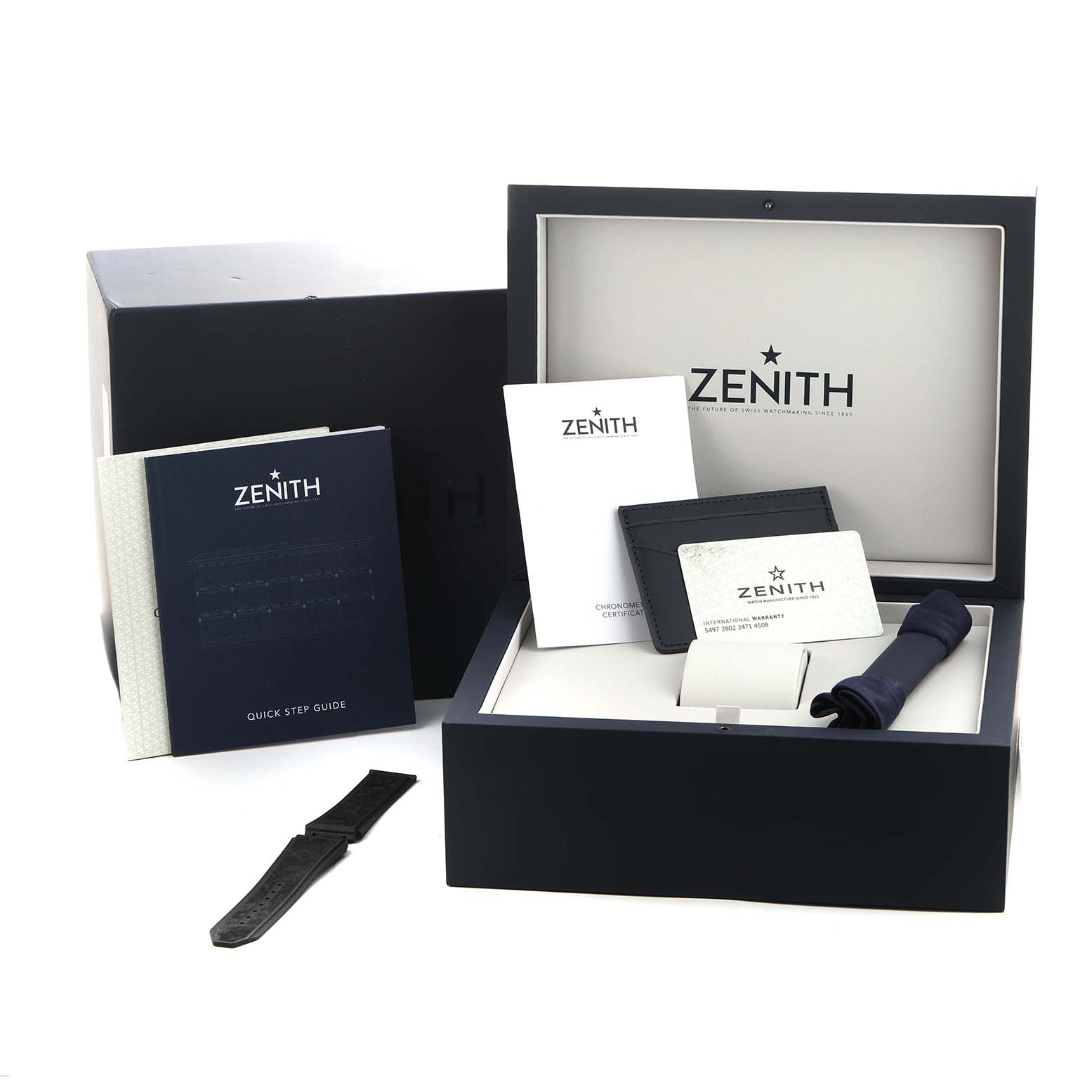 The image shows the Zenith Defy 10.9000.9020/79.R918 Men's Titanium Blue Dial watch accessories, including the box, manuals, a strap, and a certificate, viewed from above.