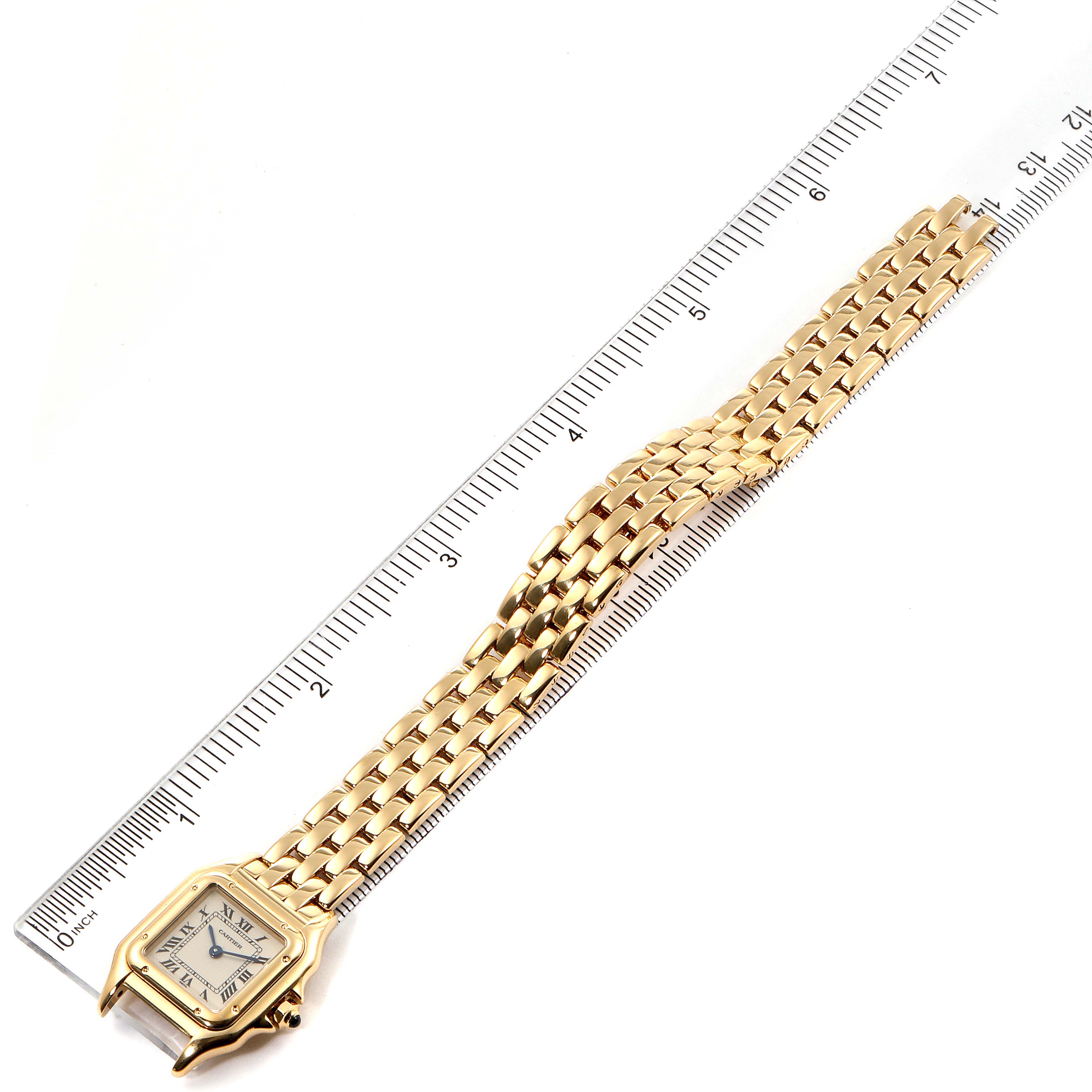 The Cartier Panthere W25022B9 Women
s Yellow Gold Silver Dial W25022B9 Women
s Yellow Gold Silver Dial watch is shown from a top-down angle, highlighting the face, bracelet, and a ruler for scale.