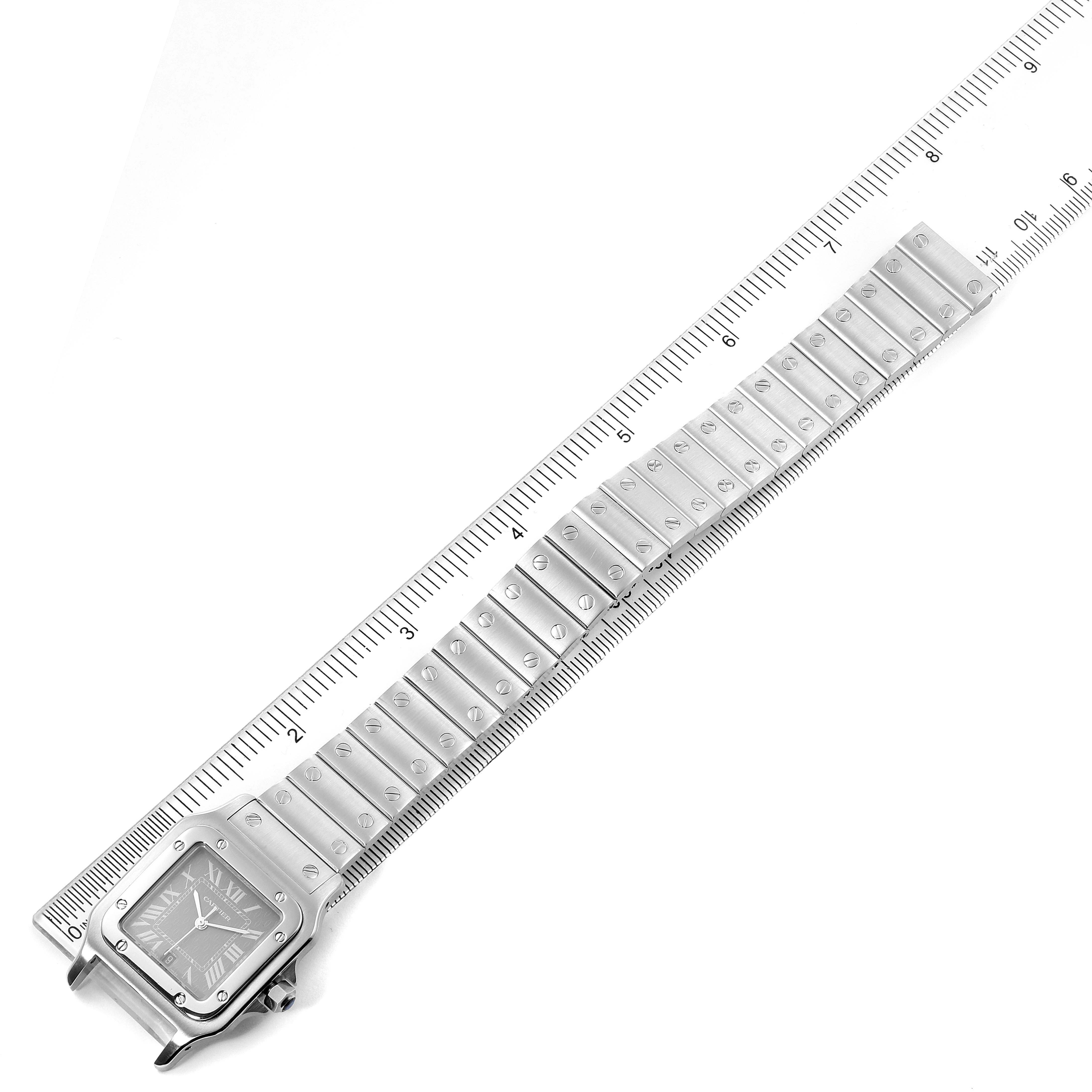 This image shows the Santos model by Cartier laid flat, displaying the full face and bracelet, alongside a ruler for scale.