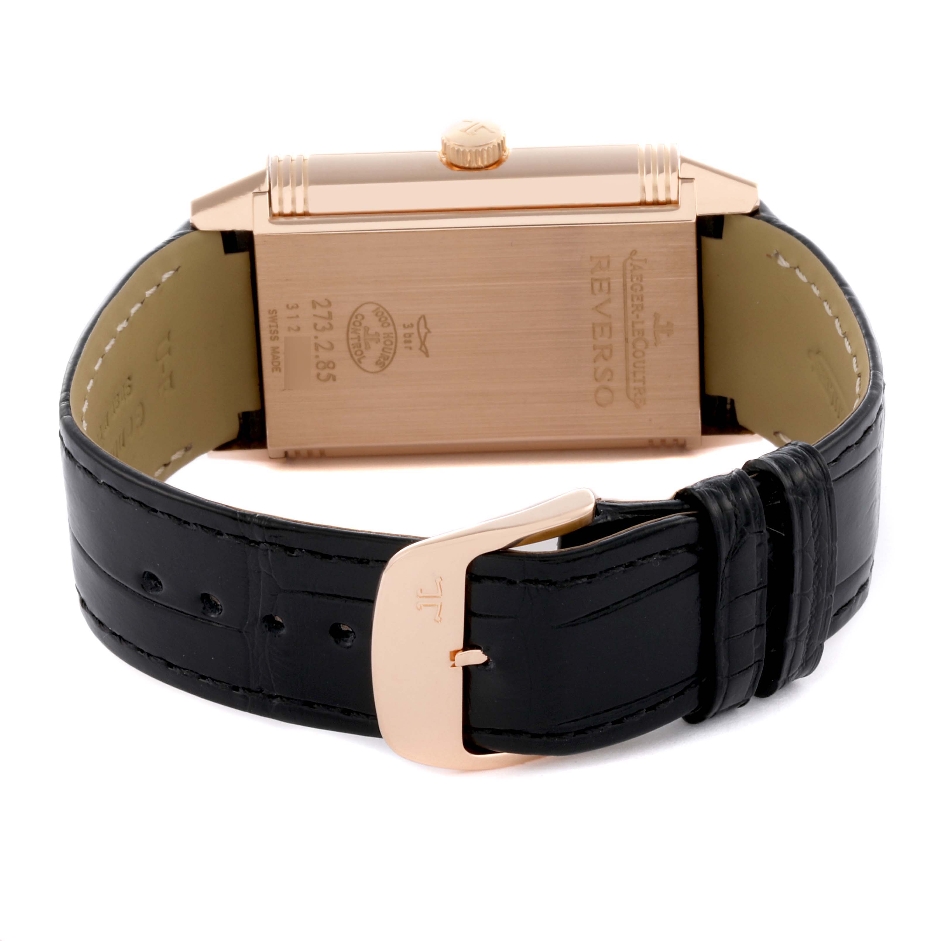 The image shows the back of the Jaeger-LeCoultre Reverso watch, highlighting the case back and black leather strap with a buckle.