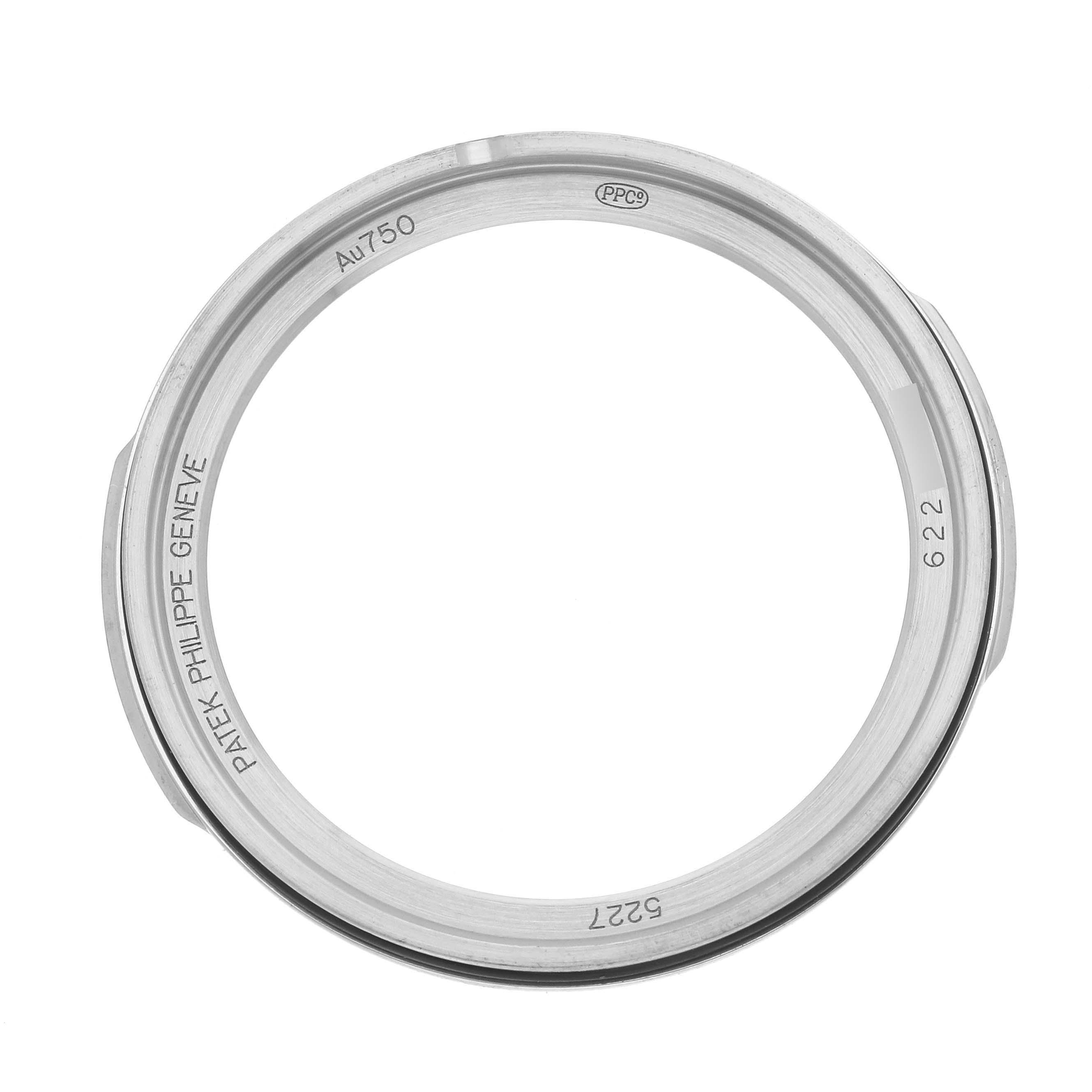 The image shows a top view of the Patek Philippe Calatrava 5227G-001 Men's White Gold Beige Dial 5227G-001 Men's White Gold Beige Dial watch bezel, displaying engravings and metal composition.