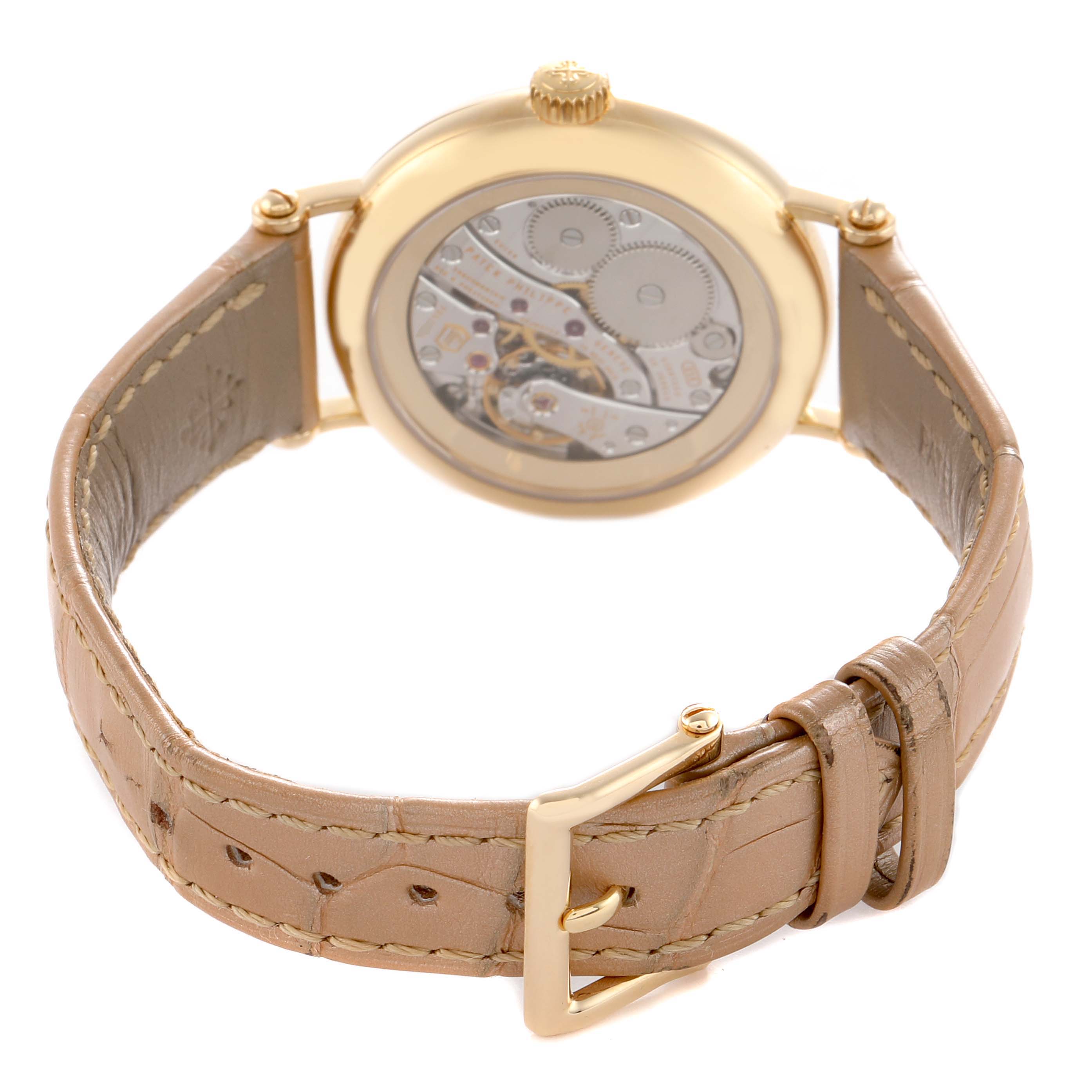 The Patek Philippe Calatrava 7121J-001 Women's Yellow Gold Silver Dial watch is shown from the back, highlighting the movement and leather strap with a gold buckle.