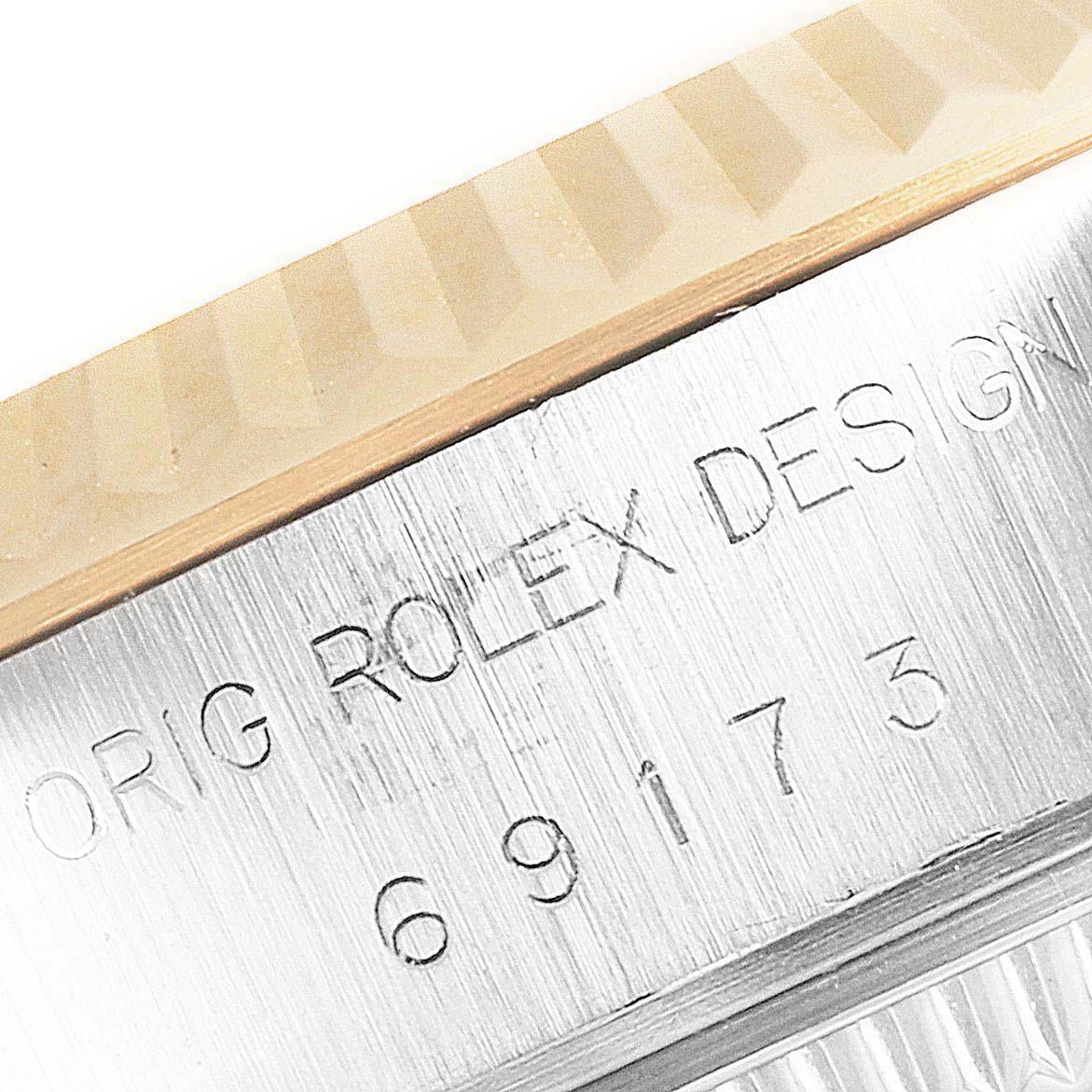 This close-up image shows the fluted bezel and the engraved serial number of a Rolex Datejust 69173 Women
s Steel and Gold (two tone) Champagne Dial 69173 Women
s Steel and Gold (two tone) Champagne Dial watch.