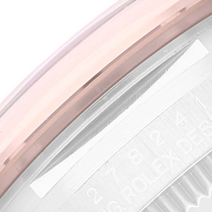 This close-up image of a Rolex Mid-Size 278241 Women's Steel and Gold (two tone) Pink Dial 278241 Women's Steel and Gold (two tone) Pink Dial model shows a portion of the watch bezel and engraved text on the case.