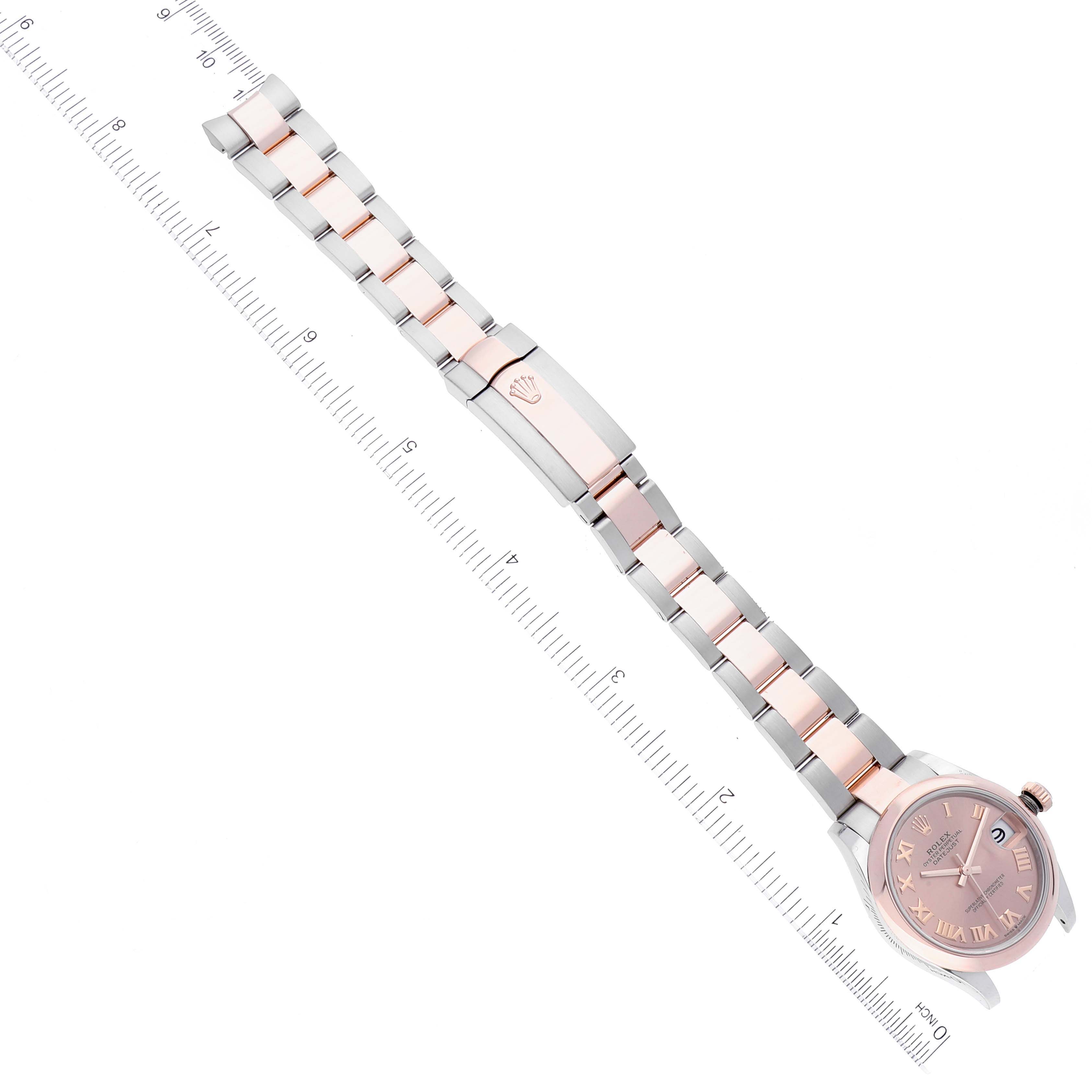 The image shows a Mid-Size Rolex watch laid flat with its bracelet extended and a ruler for scale.