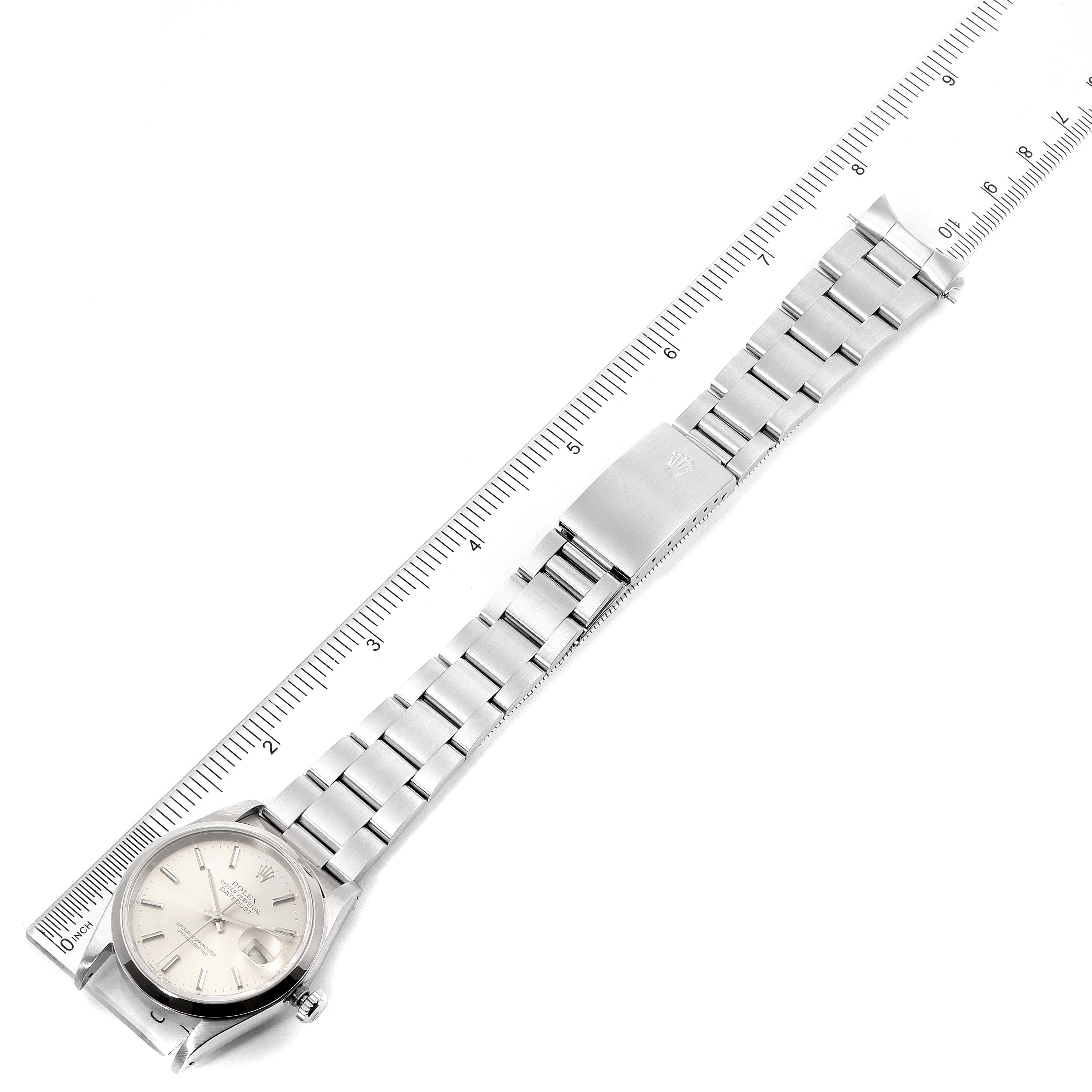 The image shows a top-down view of a Rolex Datejust 16200 Men's Stainless Steel Silver Dial 16200 Men's Stainless Steel Silver Dial watch, displaying its face, bracelet, and clasp next to a ruler.