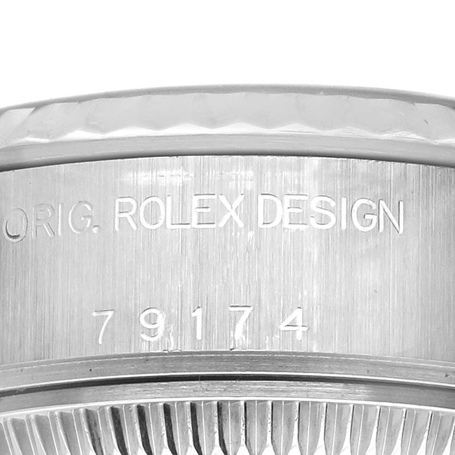 The image shows a close-up of the side view of a Rolex Datejust 79174 Women
s Stainless Steel Black Dial 79174 Women
s Stainless Steel Black Dial, focusing on the case with engraved text.