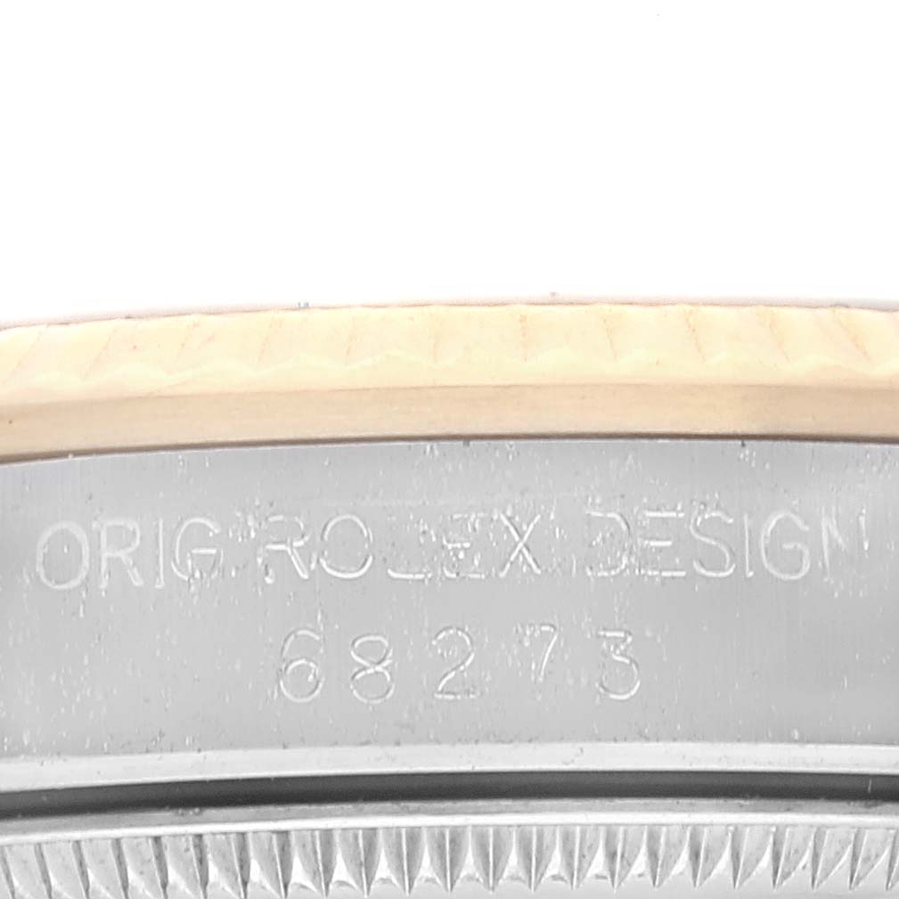 This close-up image shows part of the bezel and case side, displaying the engraved text and serial number of the Rolex Mid-Size 68273 Women
s Steel and Gold (two tone) Champagne Dial 68273 Women
s Steel and Gold (two tone) Champagne Dial model.