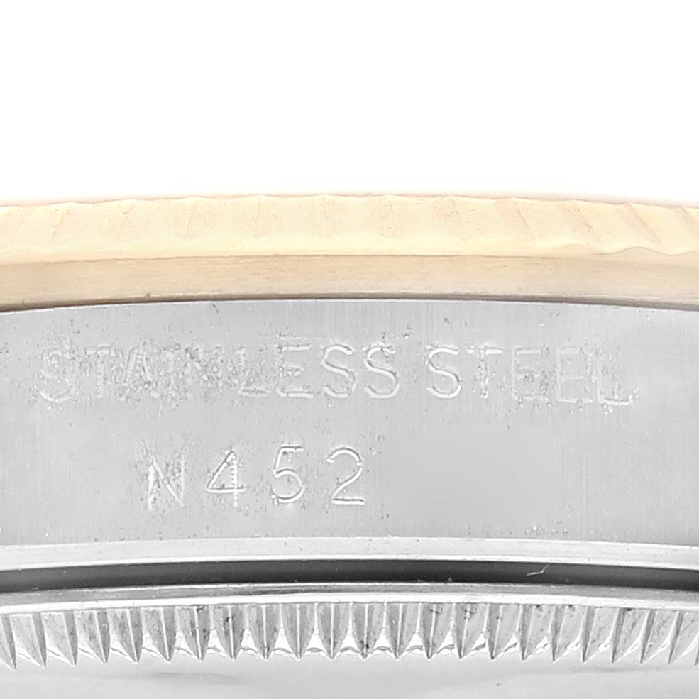 This close-up image shows the side of the Mid-Size Rolex watch case, including the engraved "Stainless Steel" marking and part of the bezel.