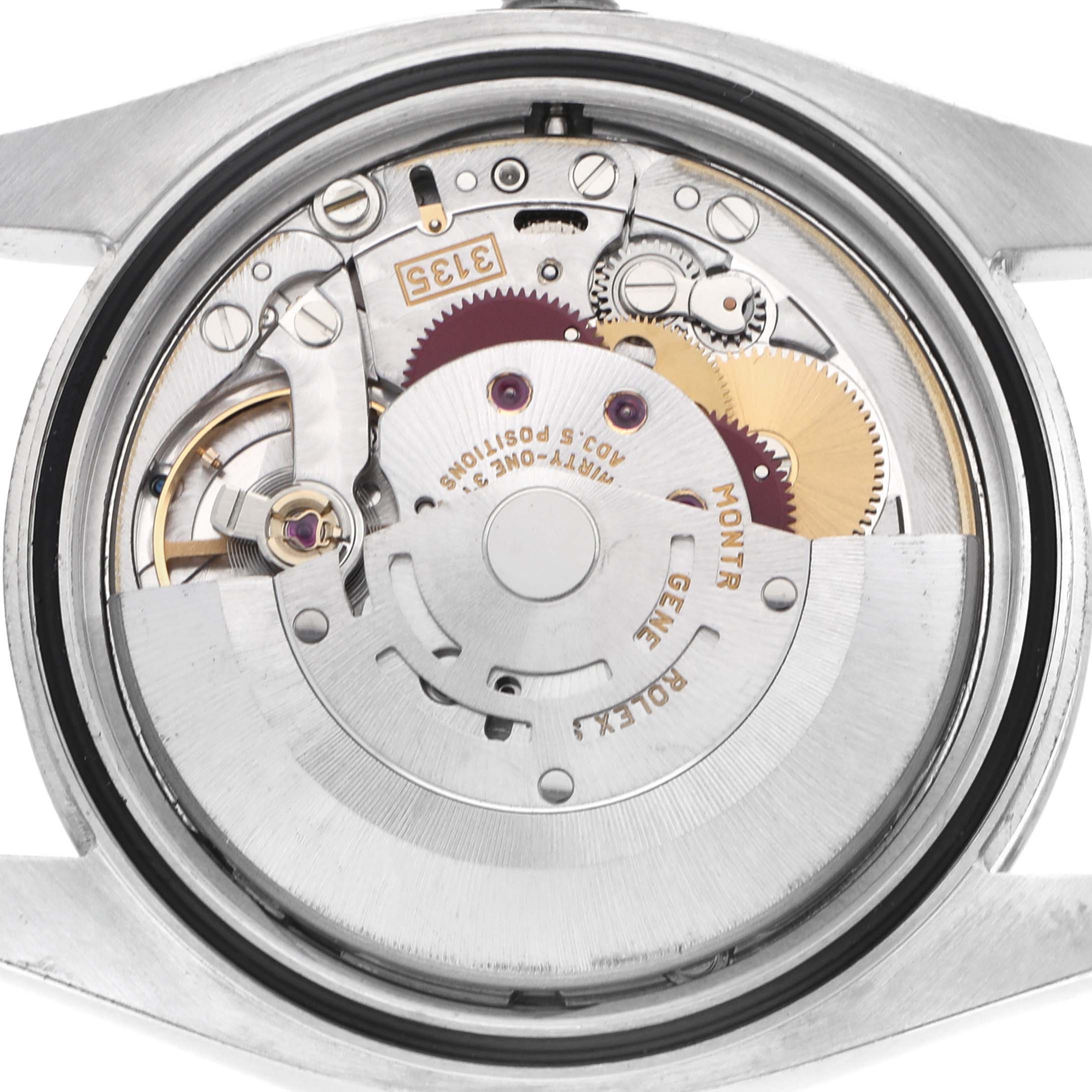 The image shows the movement of a Rolex Datejust 116200 Men's Stainless Steel Black Dial watch from the back, highlighting internal mechanics and gears.