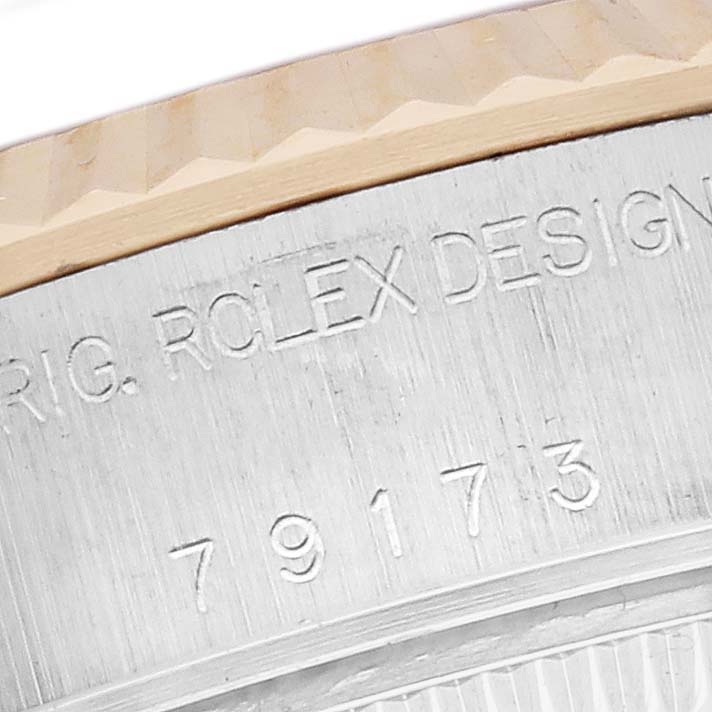 The image shows the side engraving on the bezel and caseback of a Rolex Datejust 79173 Women's Steel and Gold (two tone) White Dial 79173 Women's Steel and Gold (two tone) White Dial watch.