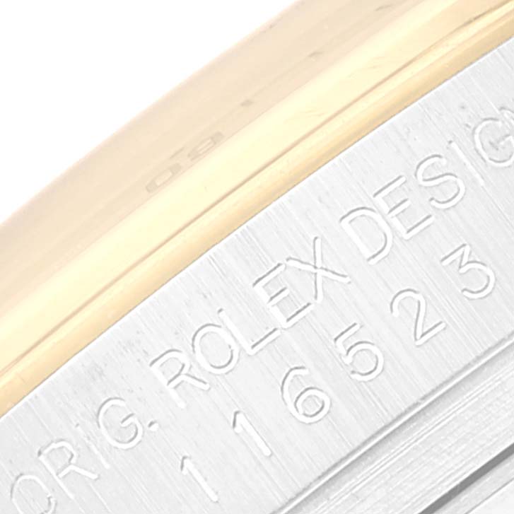 This close-up image shows the engraving on the side of the case of a Rolex Daytona 116523 Men's Steel and Gold (two tone) Black Dial 116523 Men's Steel and Gold (two tone) Black Dial watch.