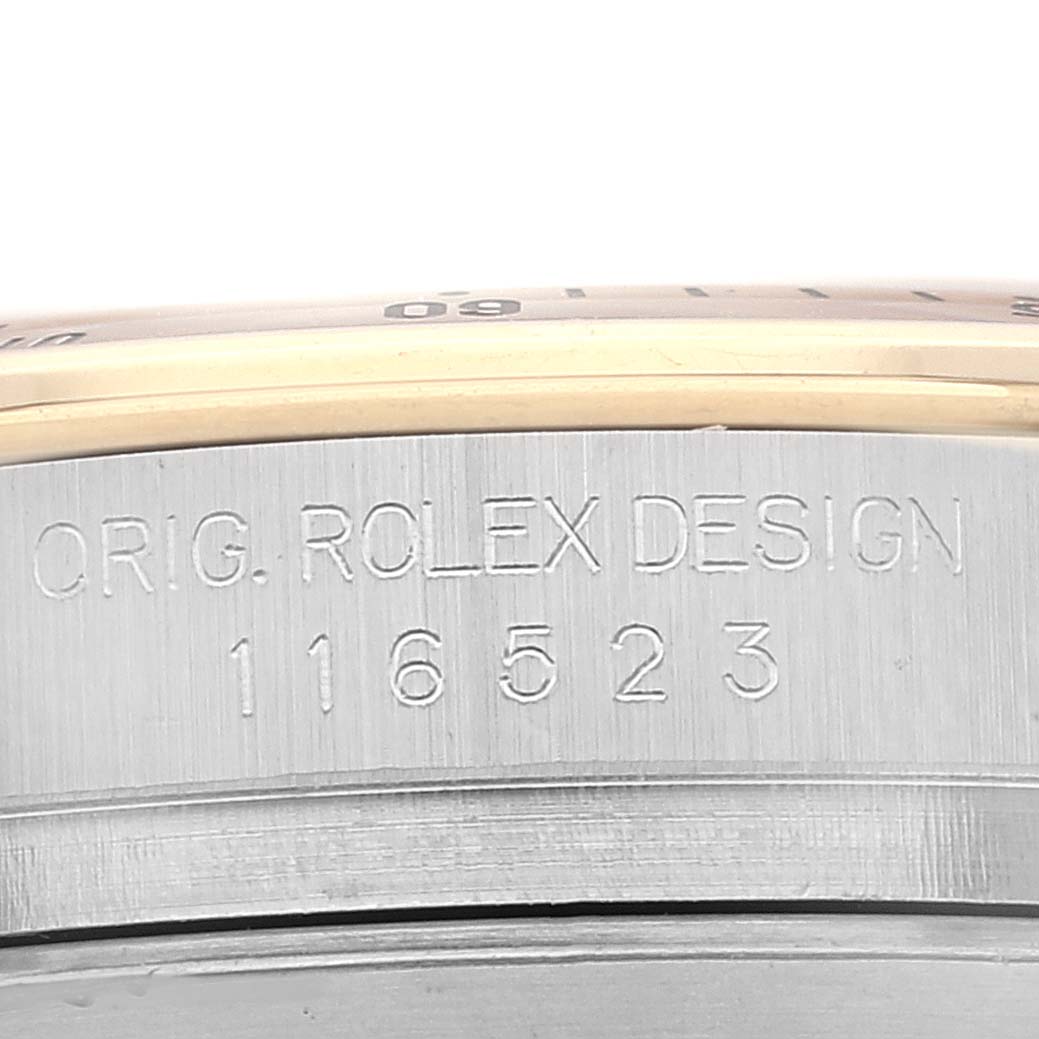 This close-up image shows the casing and model engraving of the Rolex Daytona 116523 Men's Steel and Gold (two tone) Champagne Dial 116523 Men's Steel and Gold (two tone) Champagne Dial watch.