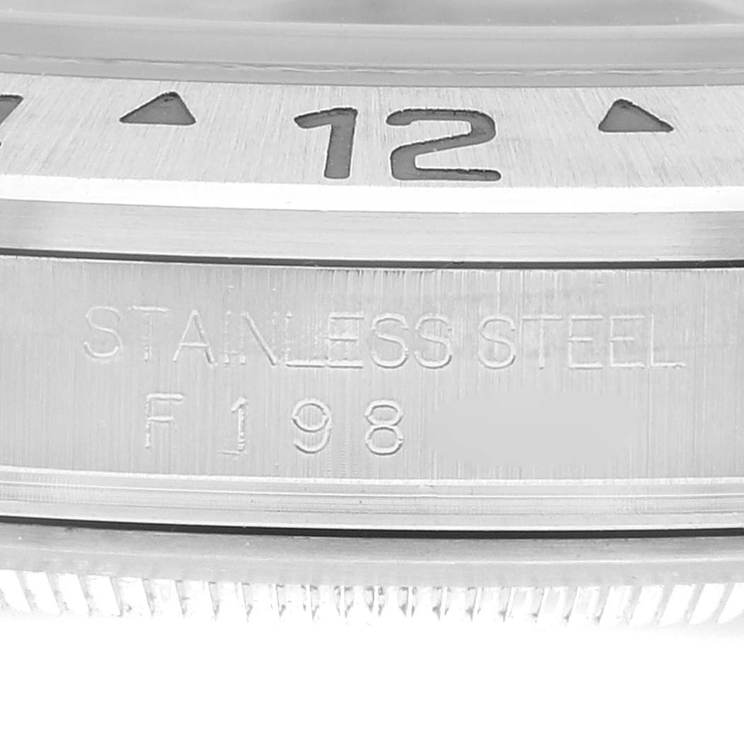 The image shows a close-up of the bezel and case with engraving details of a Rolex Explorer 16570T Men
s Stainless Steel Black Dial 16570T Men
s Stainless Steel Black Dial watch.