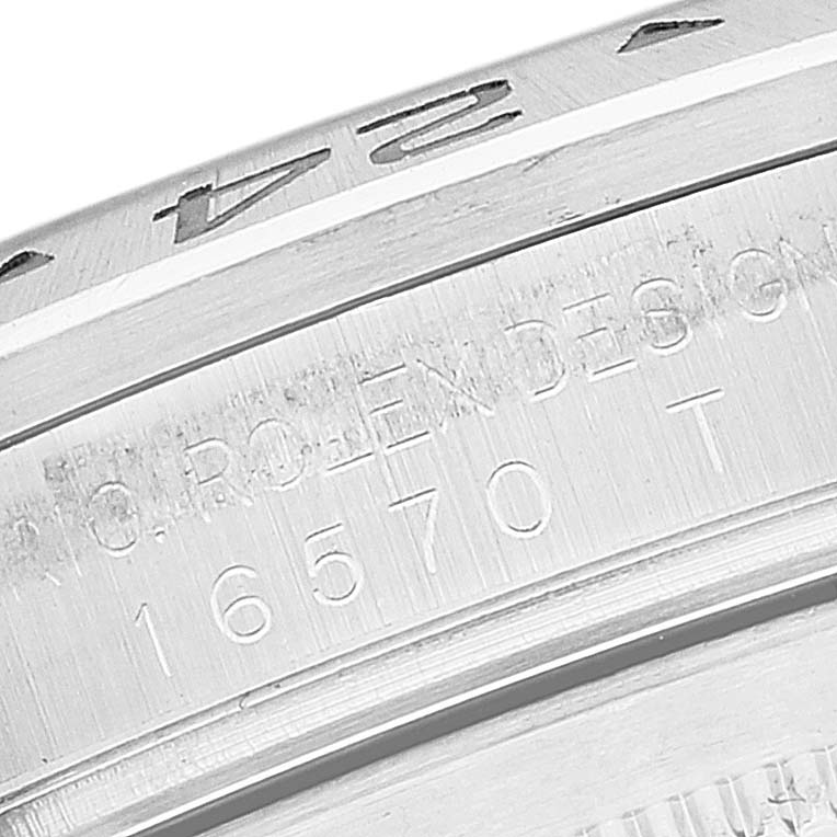 The image shows a close-up of the bezel and engravings on the case of a Rolex Explorer 16570T Men
s Stainless Steel Black Dial 16570T Men
s Stainless Steel Black Dial model 16570T watch.