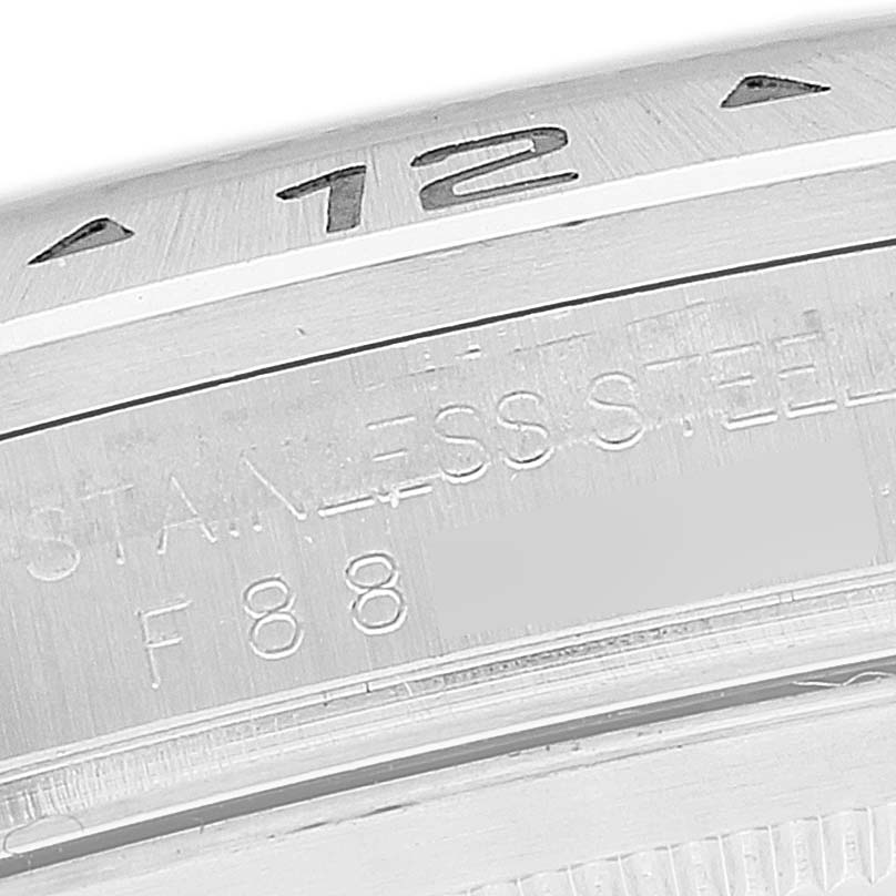 This close-up image shows the bezel and part of the casing of the Rolex Explorer 16570T Men
s Stainless Steel Black Dial 16570T Men
s Stainless Steel Black Dial watch, highlighting the "12" marker and some engraved text.