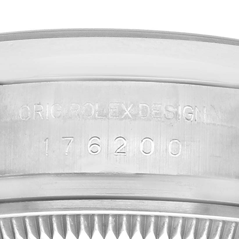 The image shows the engraved side of the Rolex Oyster Perpetual 176200 Women's Stainless Steel Silver Dial 176200 Women's Stainless Steel Silver Dial model, highlighting the case design and model number.