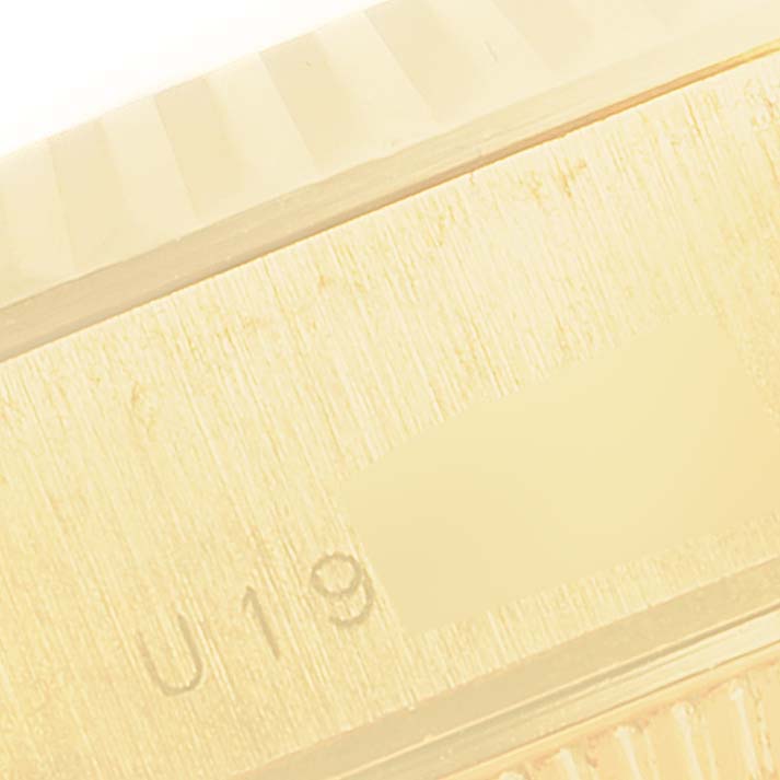 This is a close-up of the side of a Rolex President 79178 Women
s Yellow Gold Champagne Dial 79178 Women
s Yellow Gold Champagne Dial model watch, showing part of the bezel and case with serial engravings.